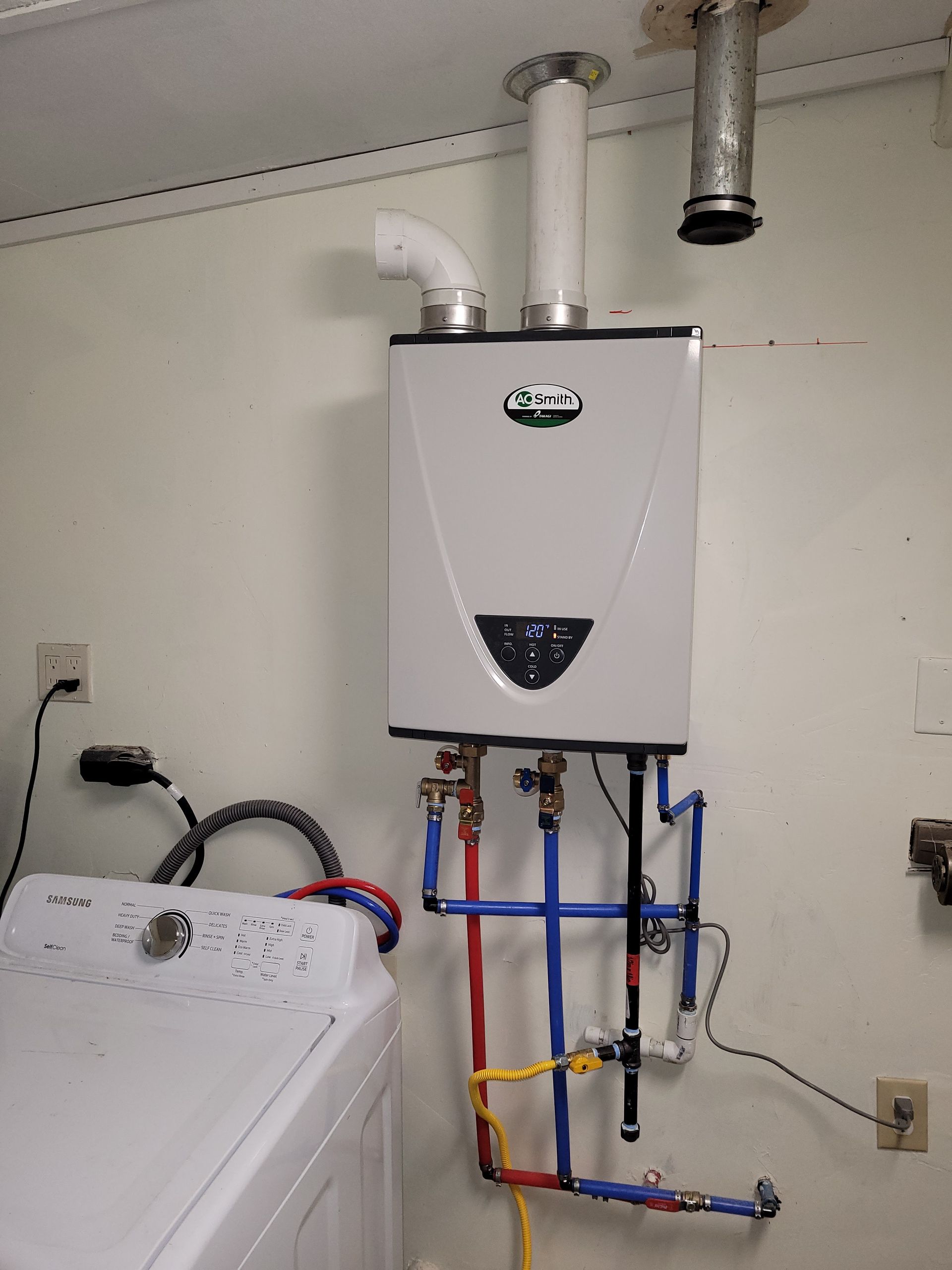 A laundry room with a washer and dryer and a water heater