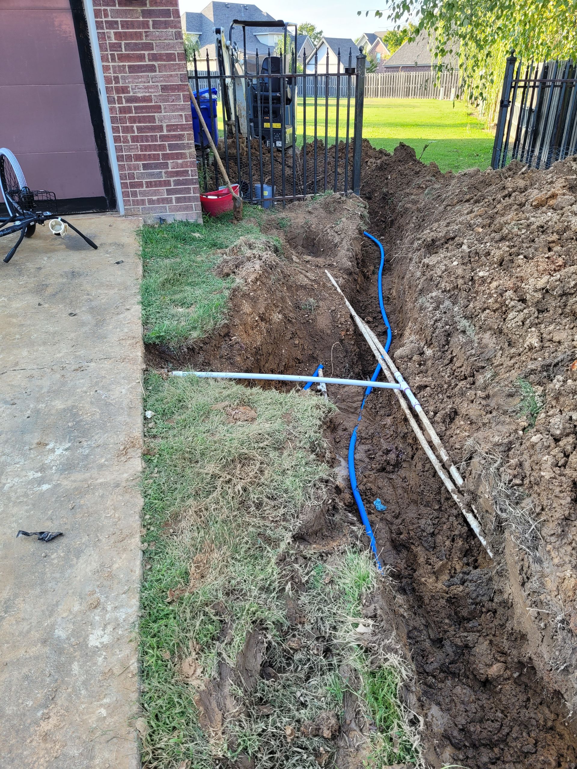 A large pile of dirt is sitting in front of a brick building.
