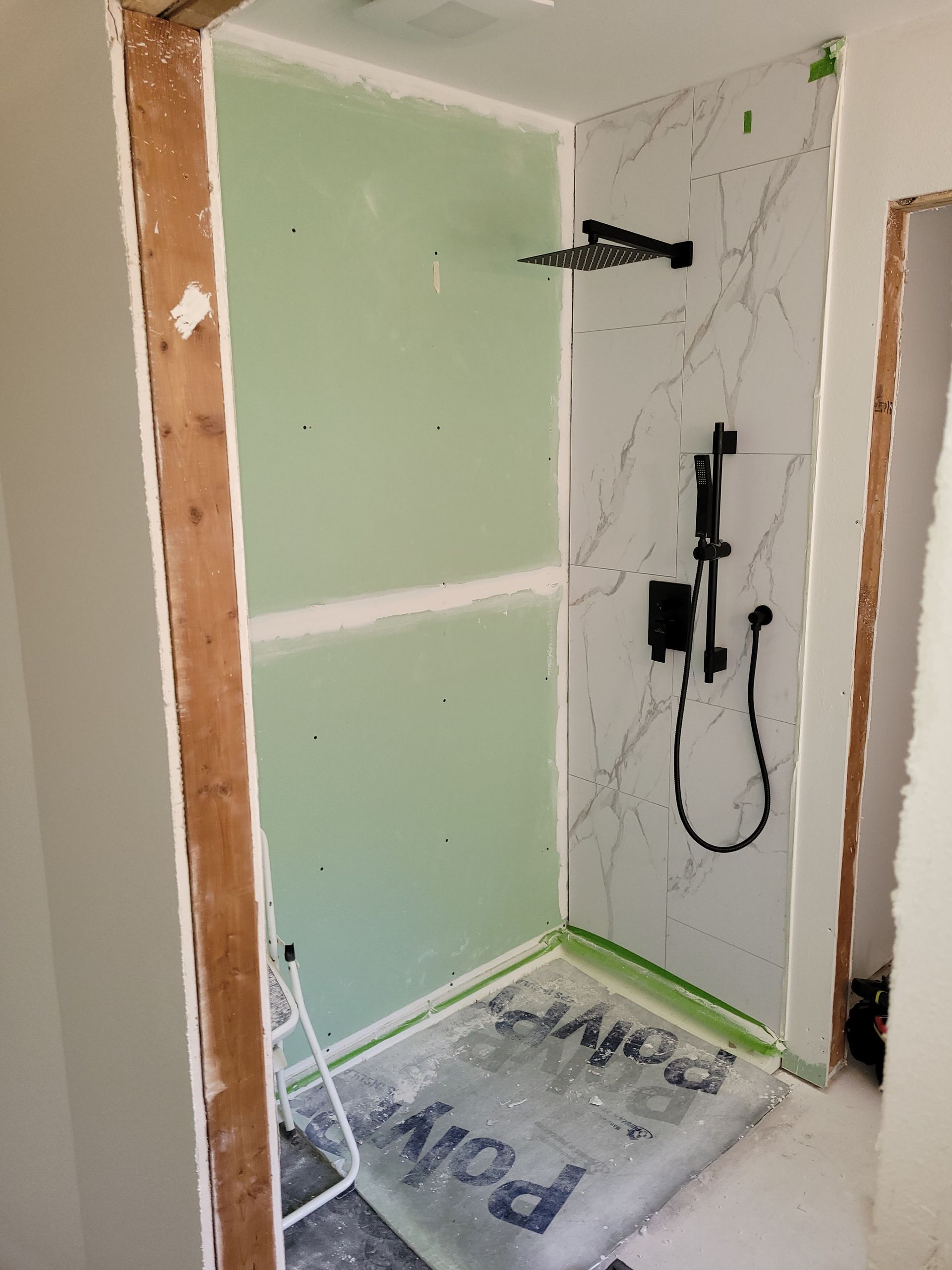 A bathroom is being remodeled with a walk in shower.