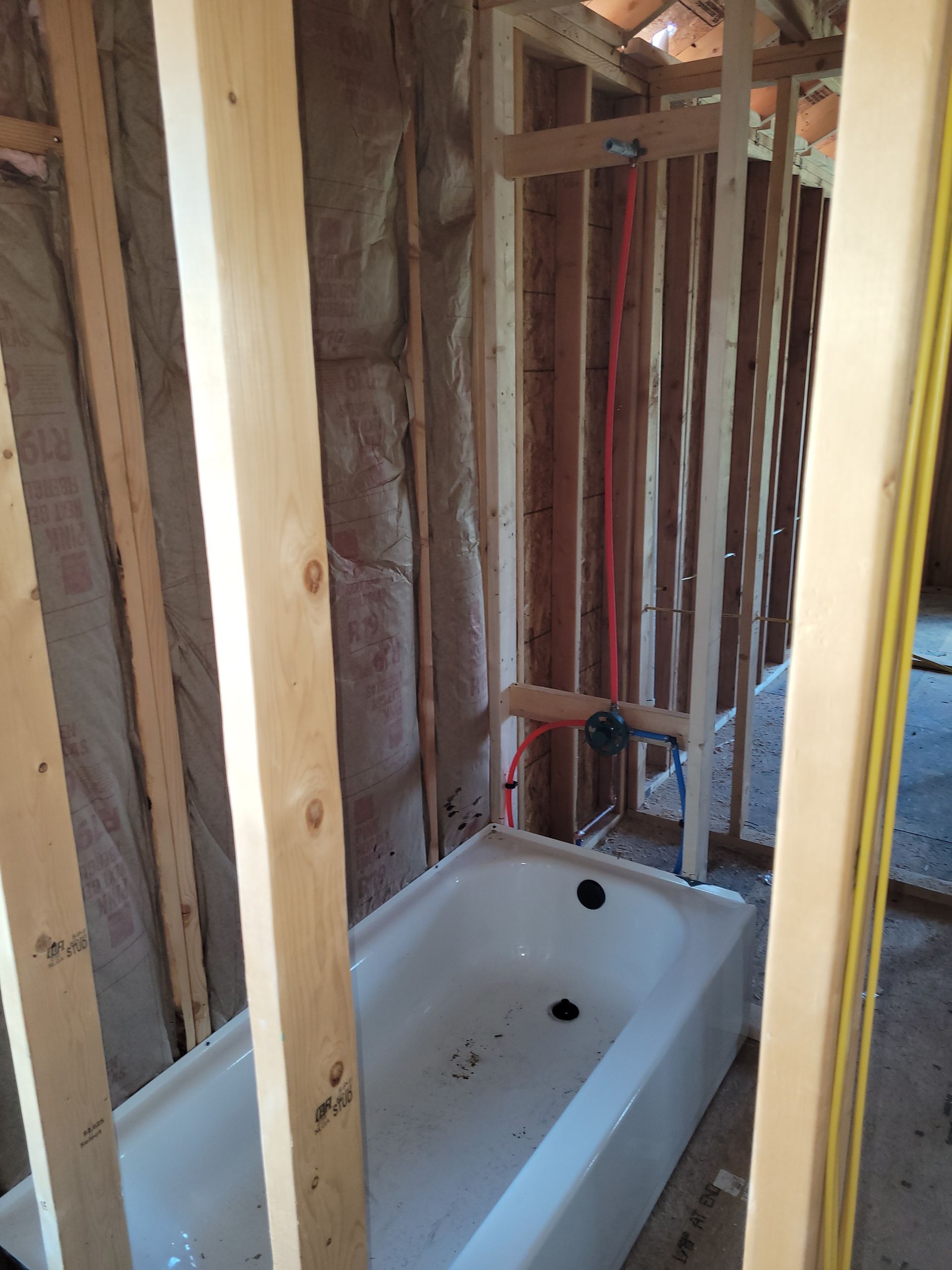 A bathtub is sitting in a room under construction.
