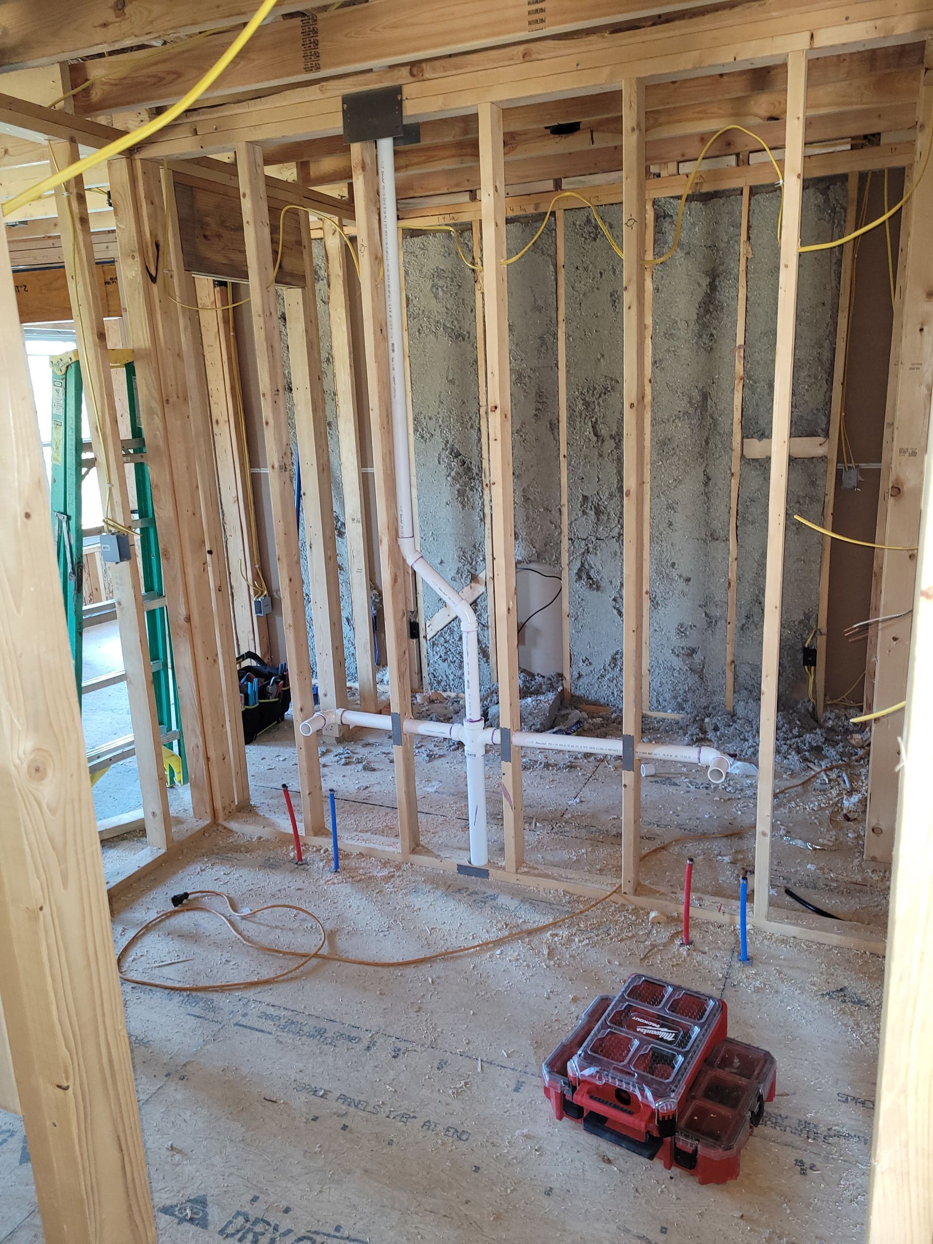 A room is being built with wooden beams and a ladder.