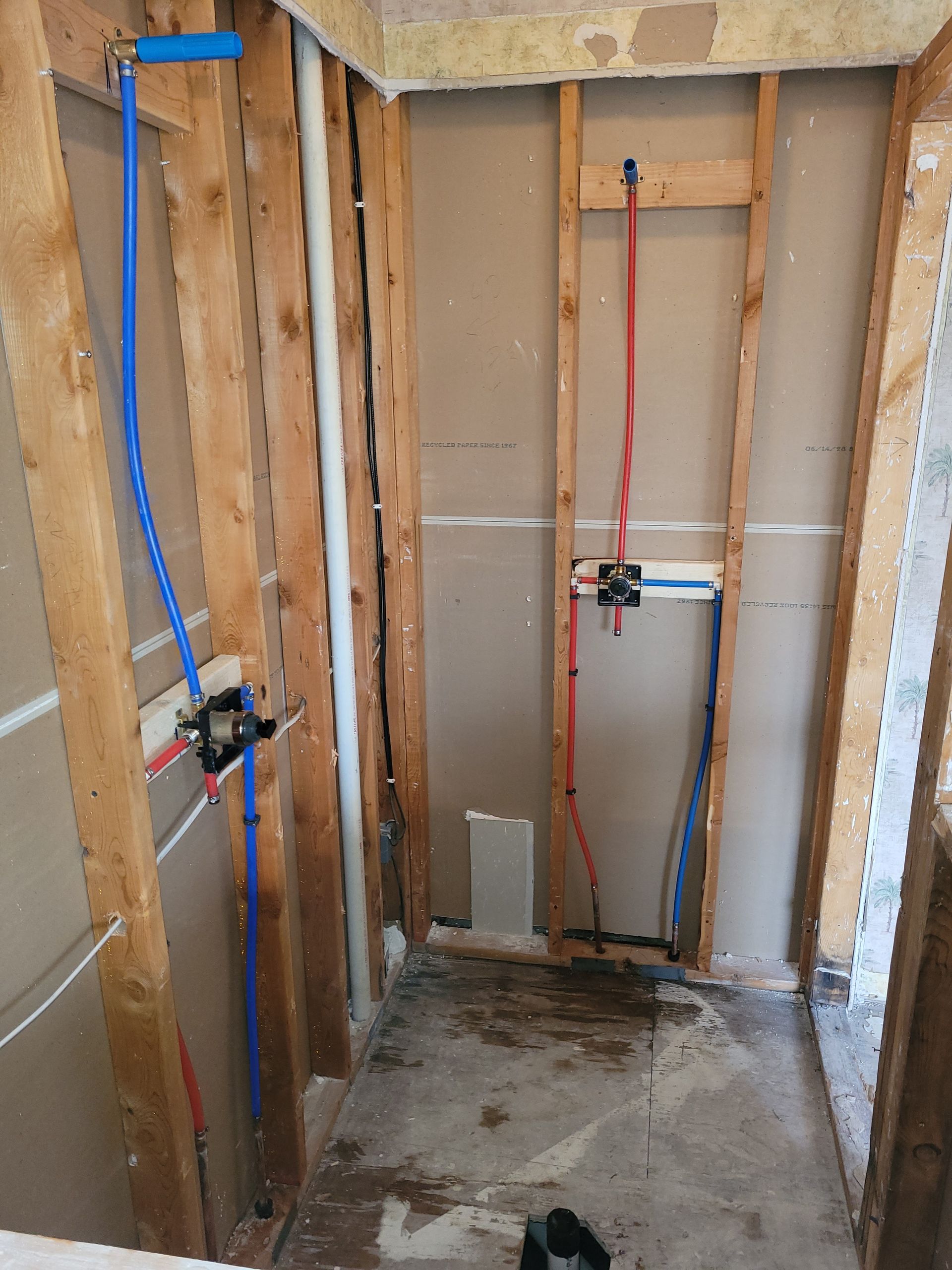 A bathroom with a lot of pipes coming out of the wall