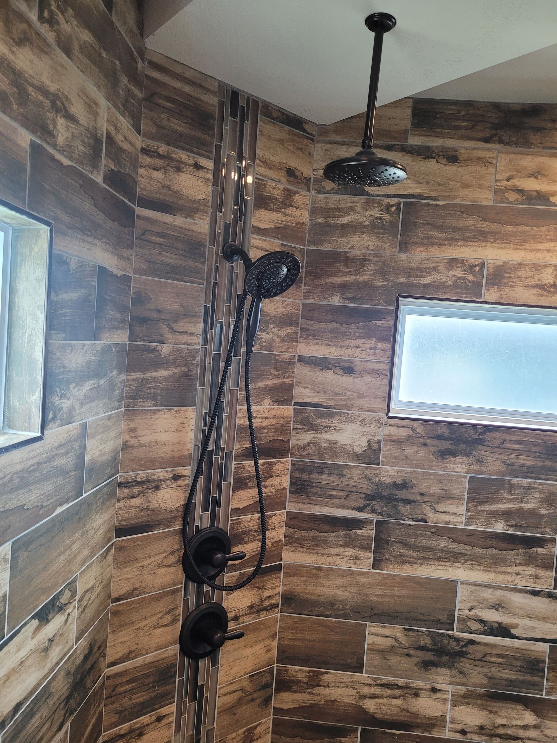 A shower with wooden tiles and a ceiling fan.