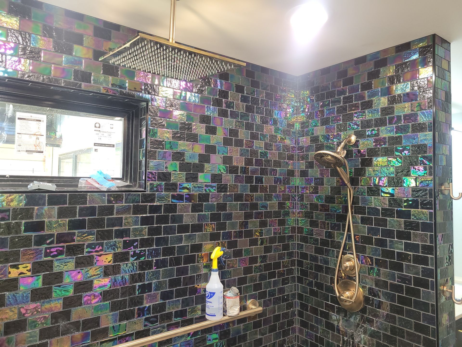 A bathroom with a shower head and a window.