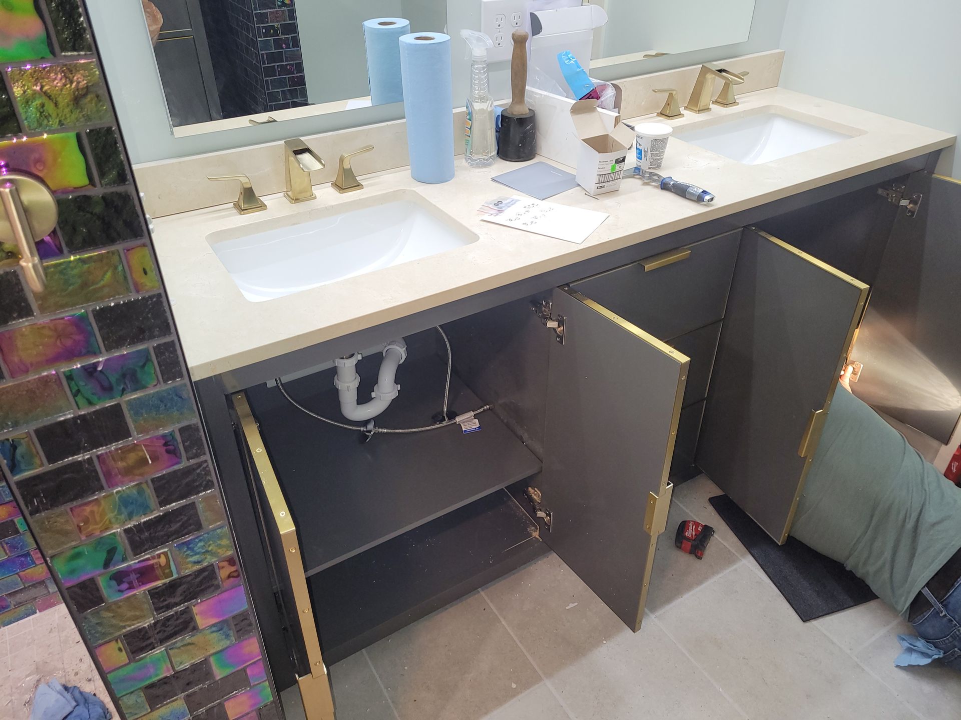 A bathroom with two sinks and a mirror with the doors open.