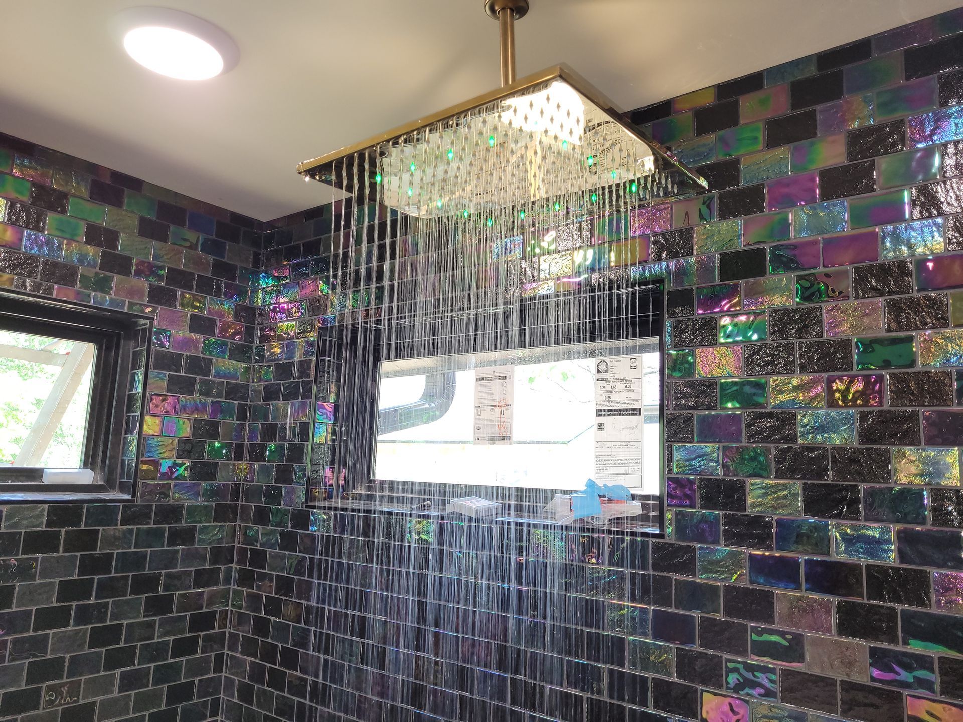 A shower head is hanging from the ceiling in a bathroom.