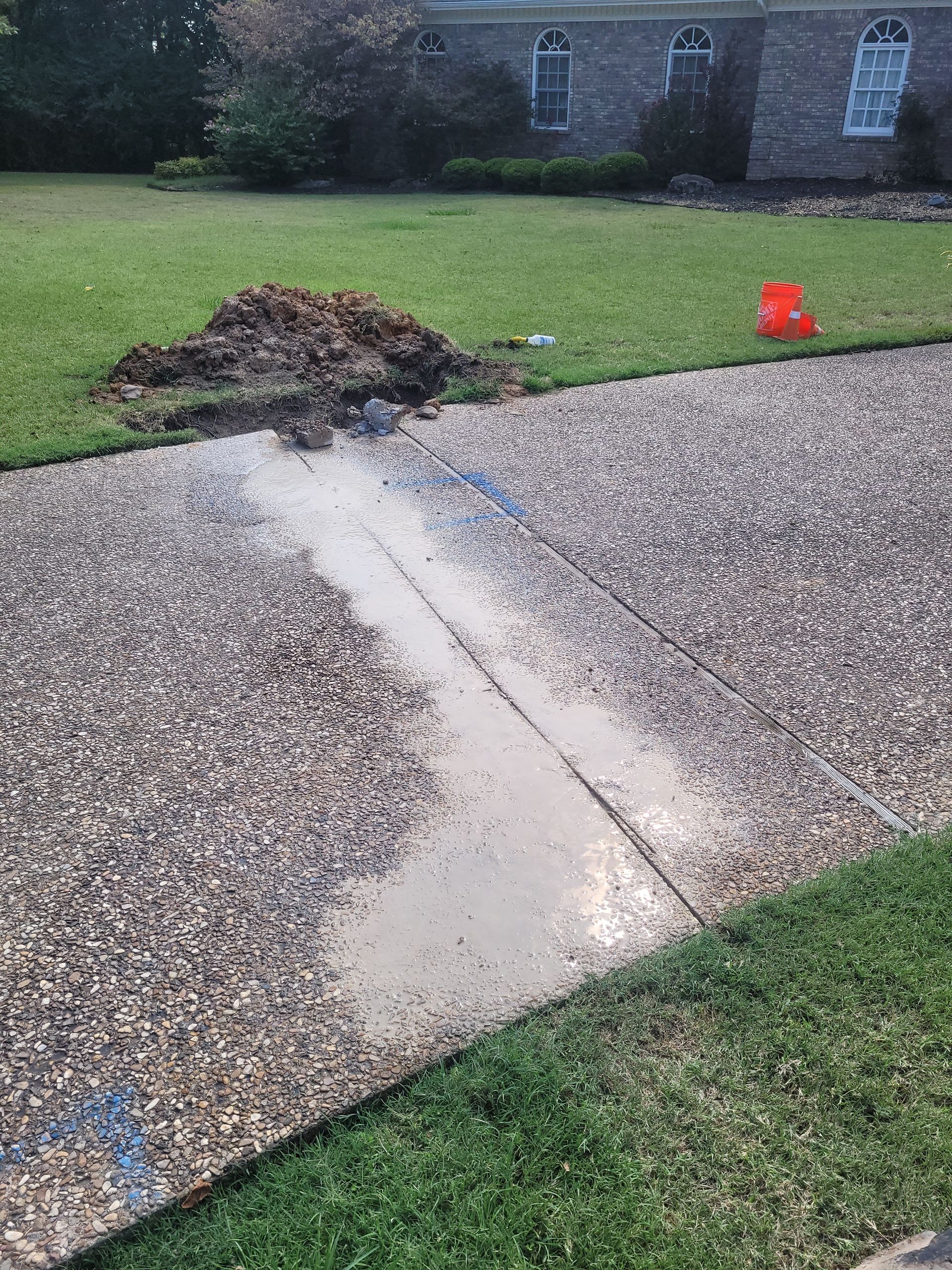 A concrete driveway with a lot of water coming out of it.