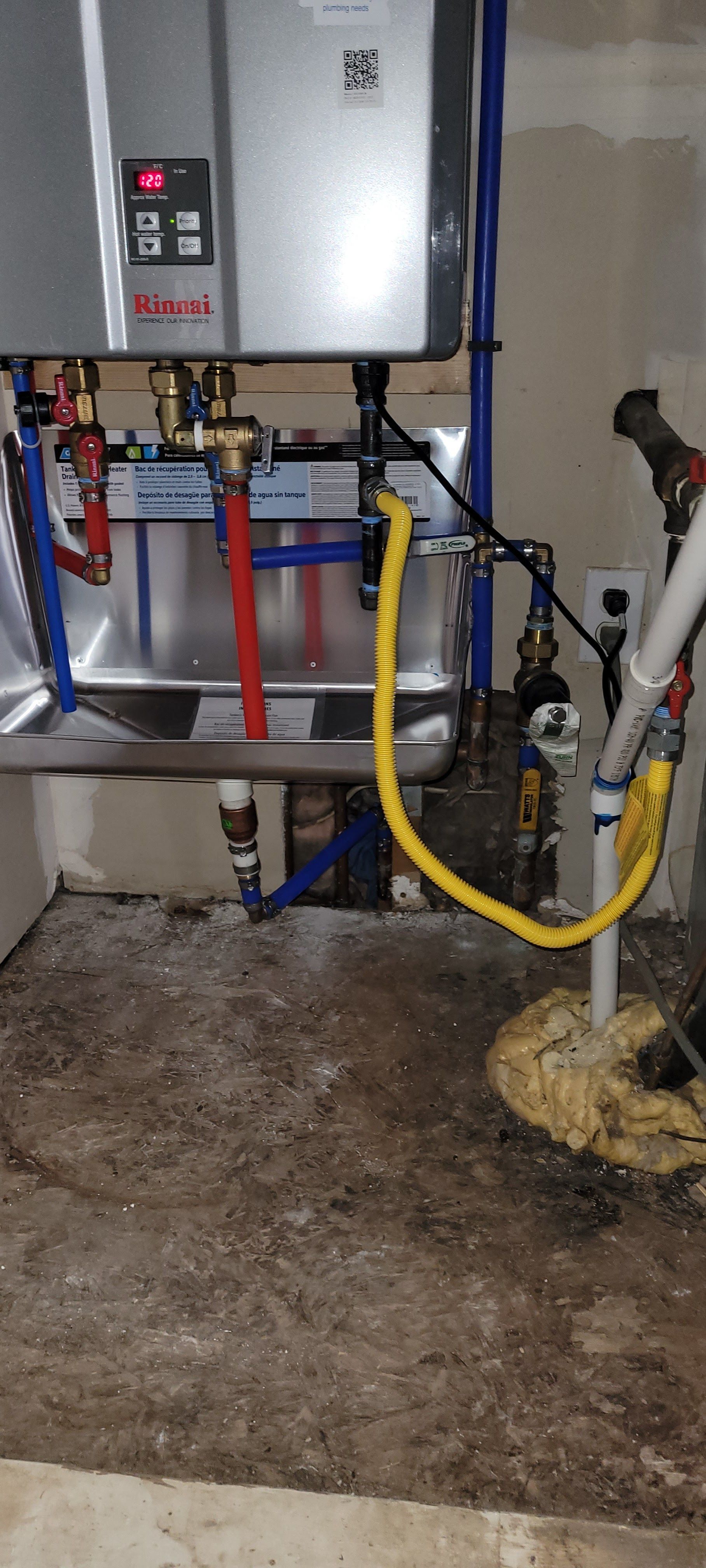 A water heater is connected to a hose in a basement.