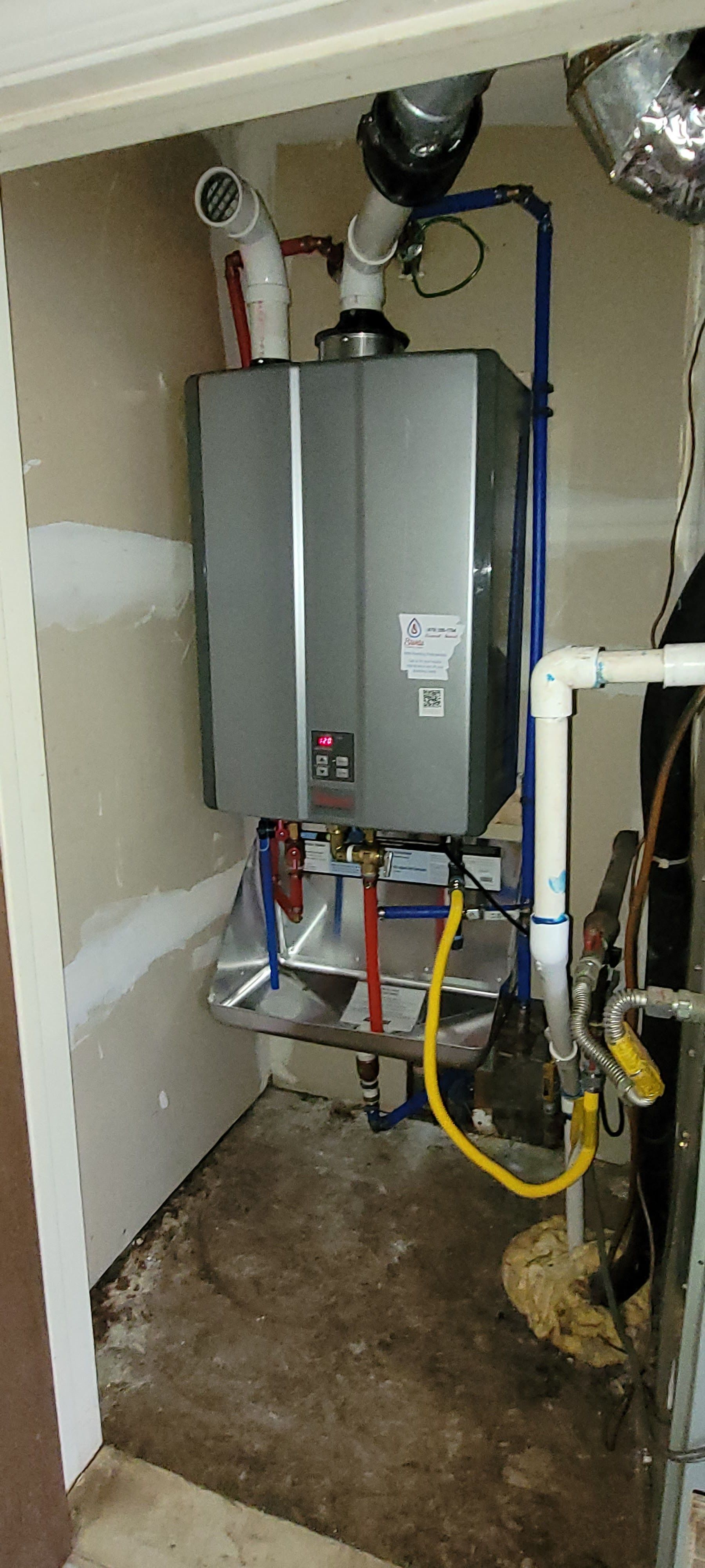 A water heater is installed in a room next to a pipe.