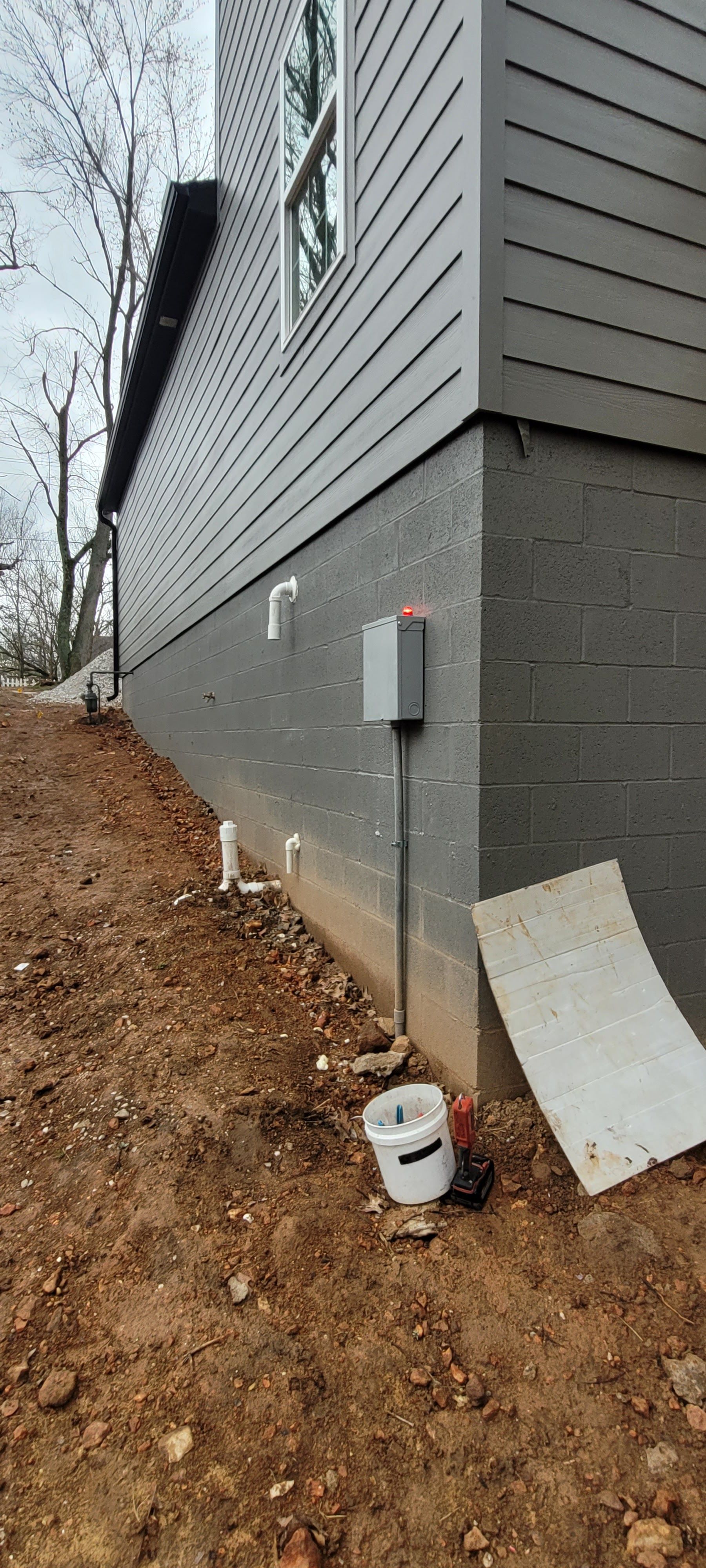 A house is being built on a dirt hill.