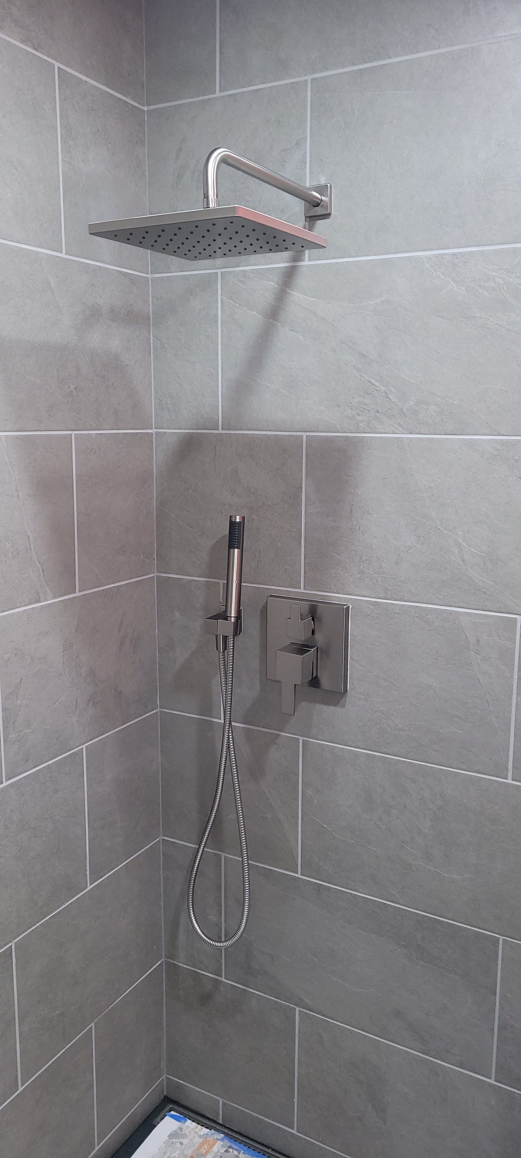 A shower head is hanging from the wall in a bathroom.