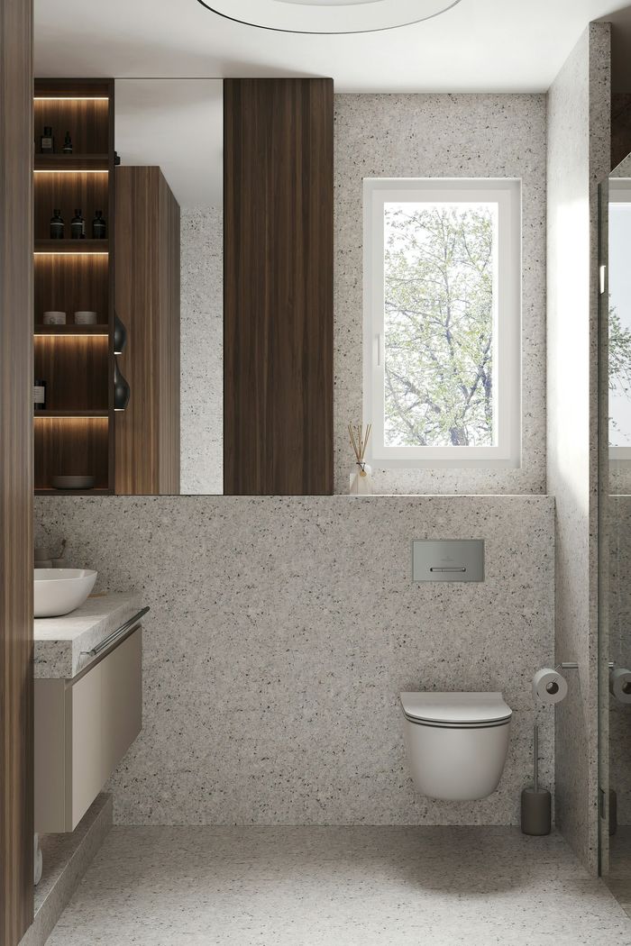 A floating toilet surrounded by speckled marble and  shelving with soft lighting contrasting the bright light from a window.