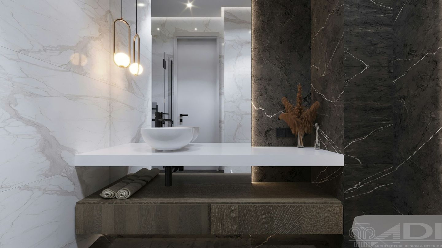 A high-end modern floating vanity surrounded by marble with a white vessel sink and black fixtures.