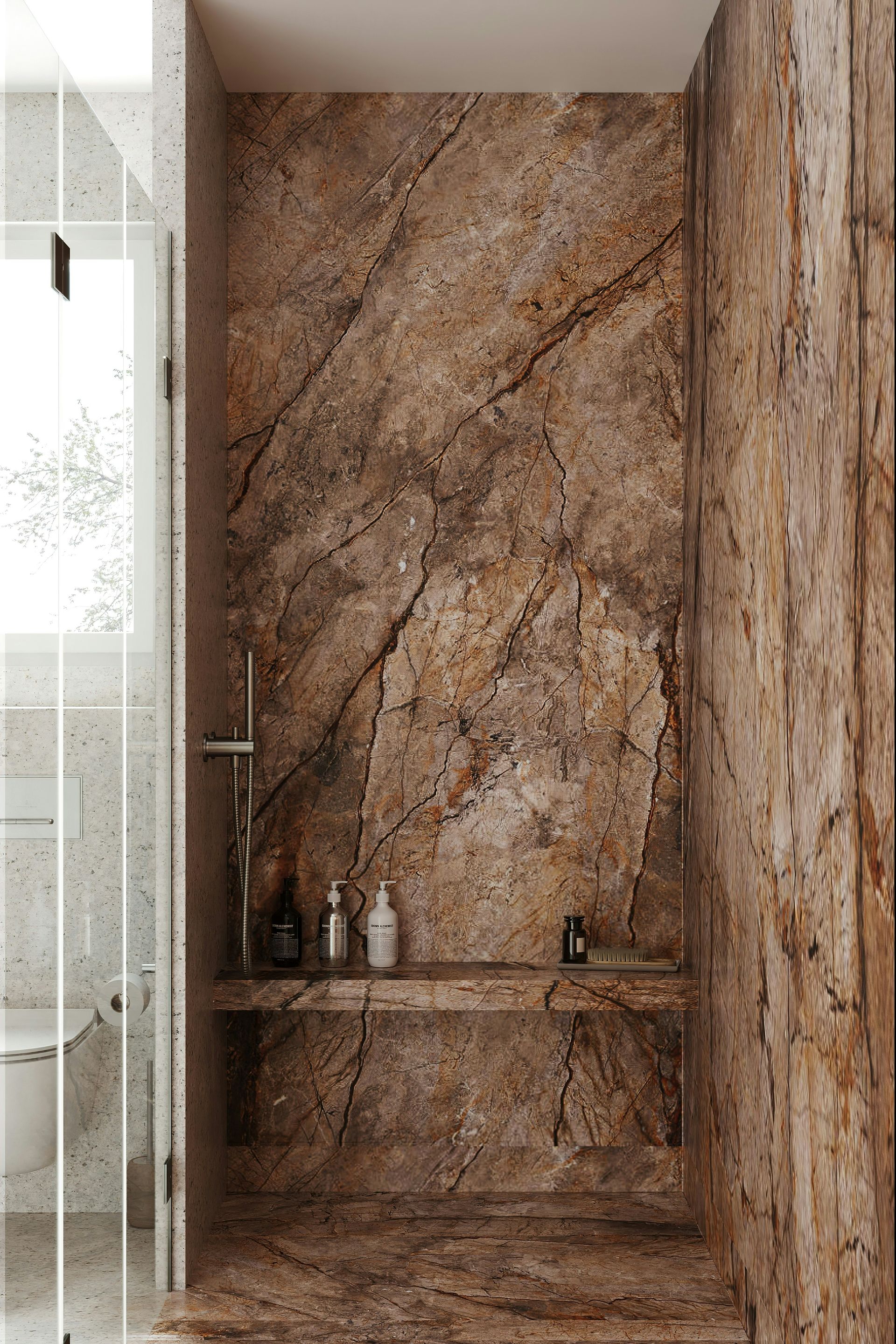 A barrier-free shower made almost entirely in a brown colored marble. The panels span from floor to ceiling in large veins.