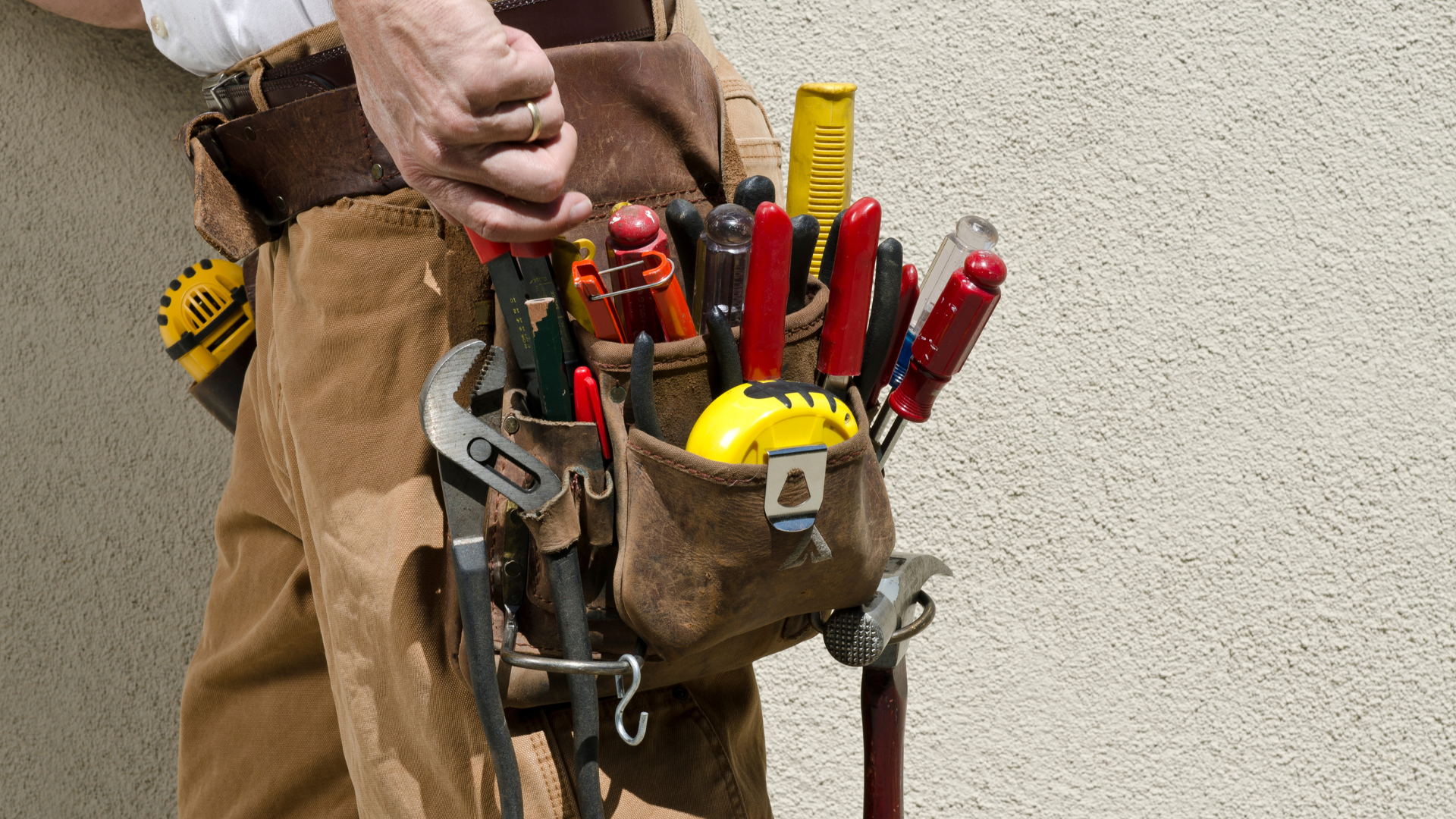 A man is wearing a tool belt filled with tools.