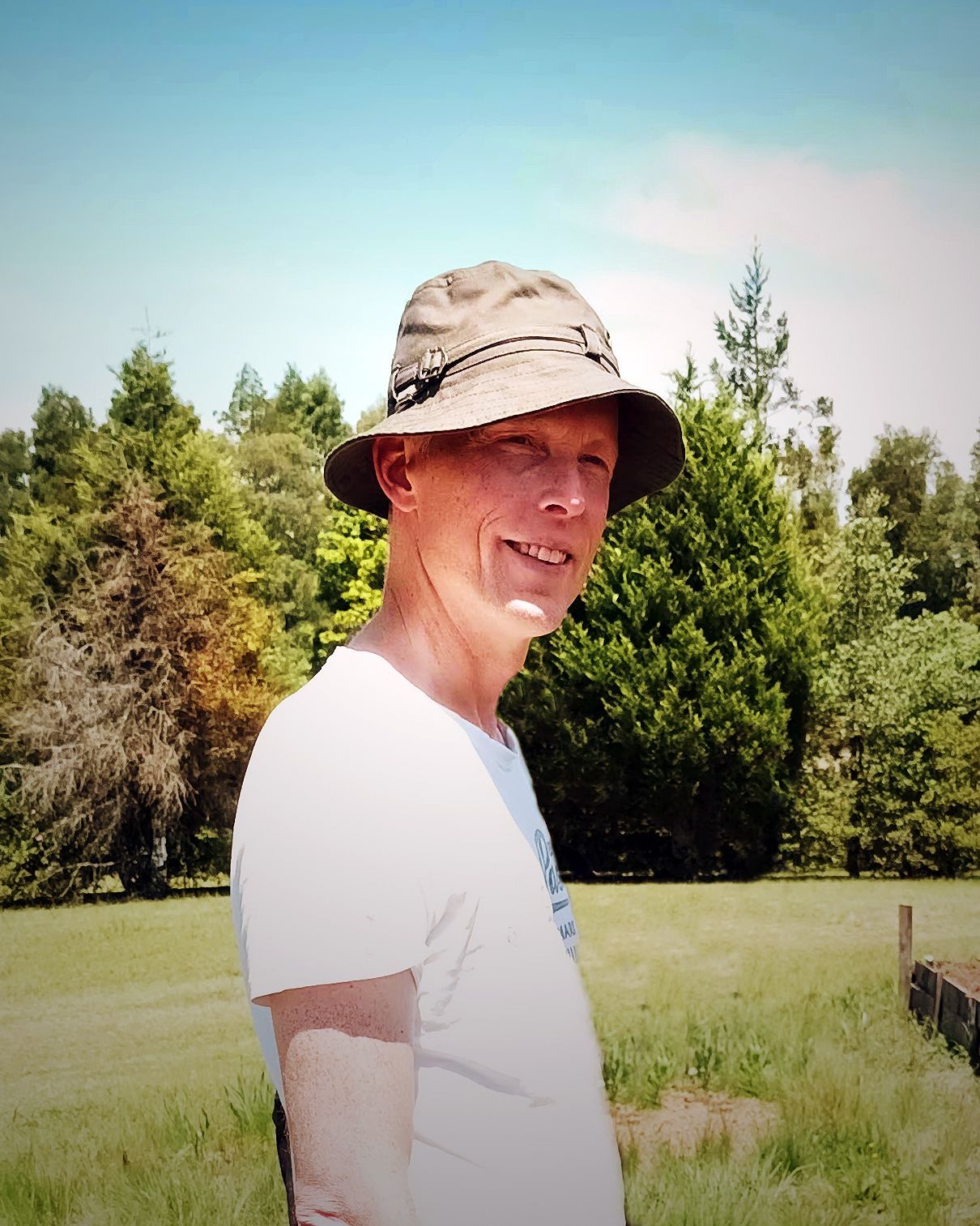 Rene staat met hoed in een veld