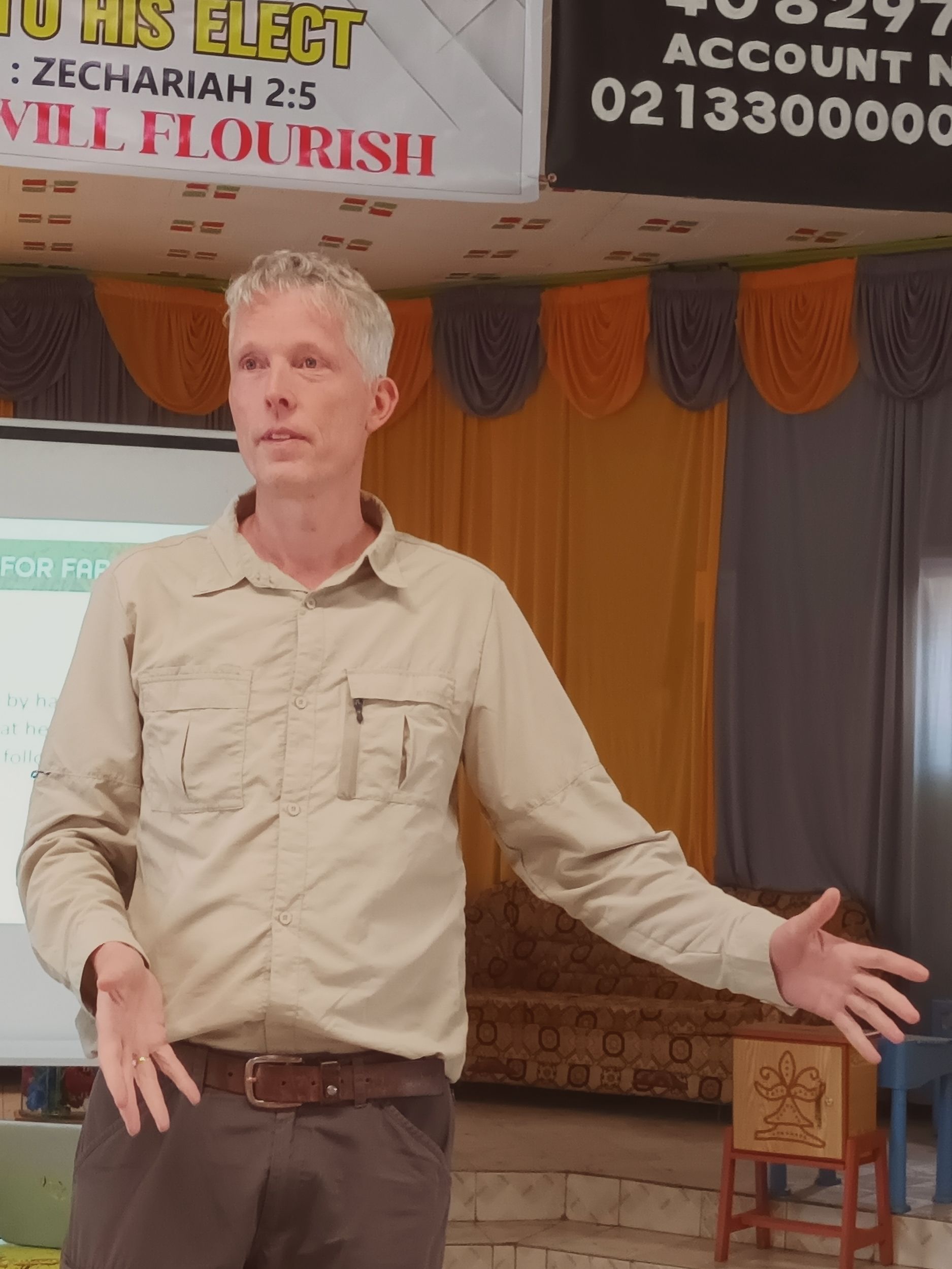 Rene staat met hoed in een veld