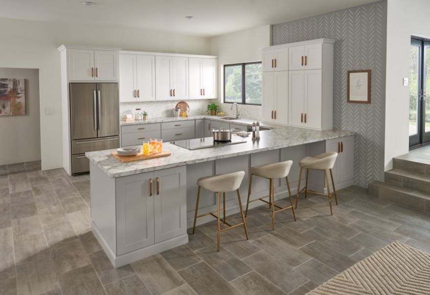 Modern kitchen with a gray island, white cabinets, and bar stools.