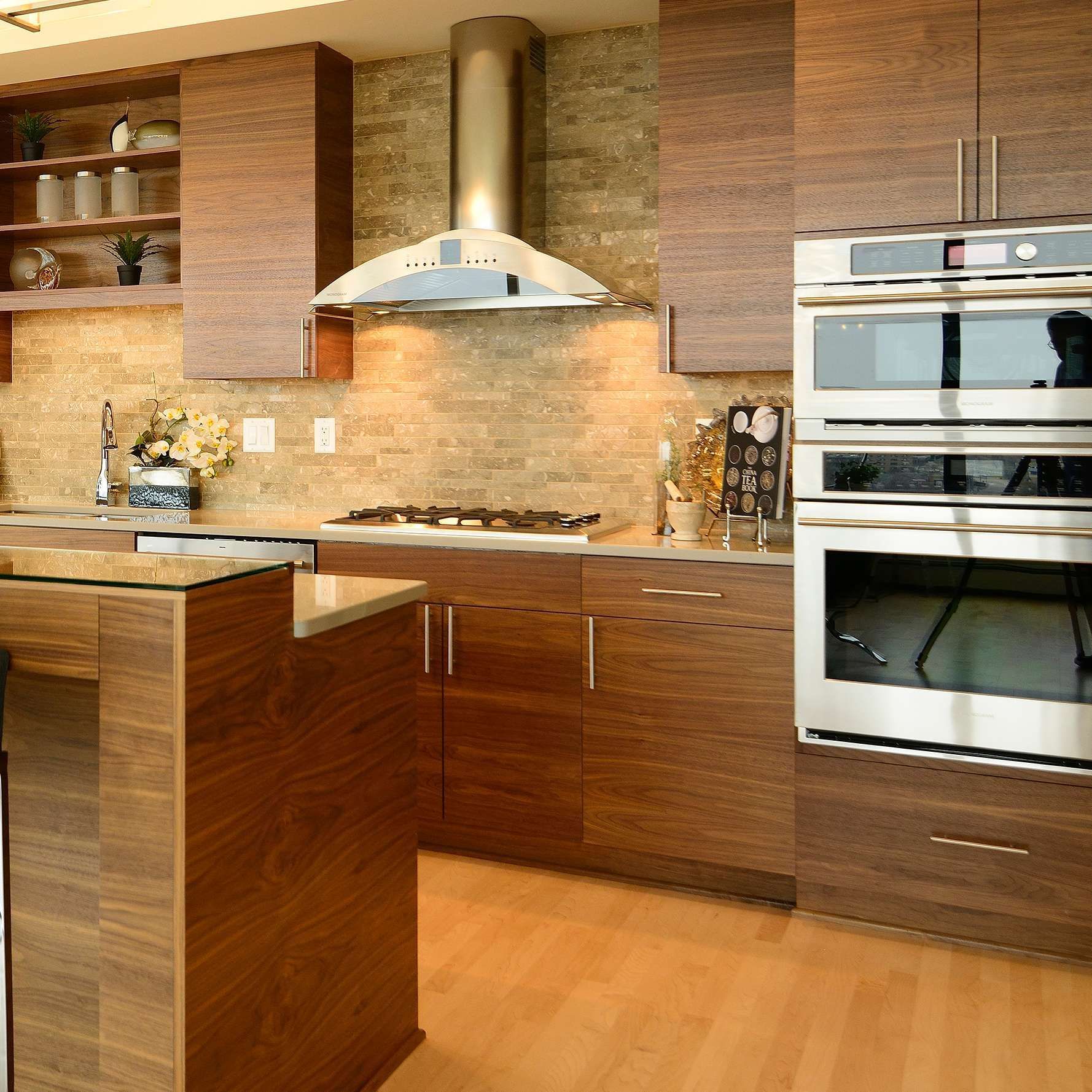 Modern kitchen with wooden cabinets, stainless steel appliances, and beige backsplash.