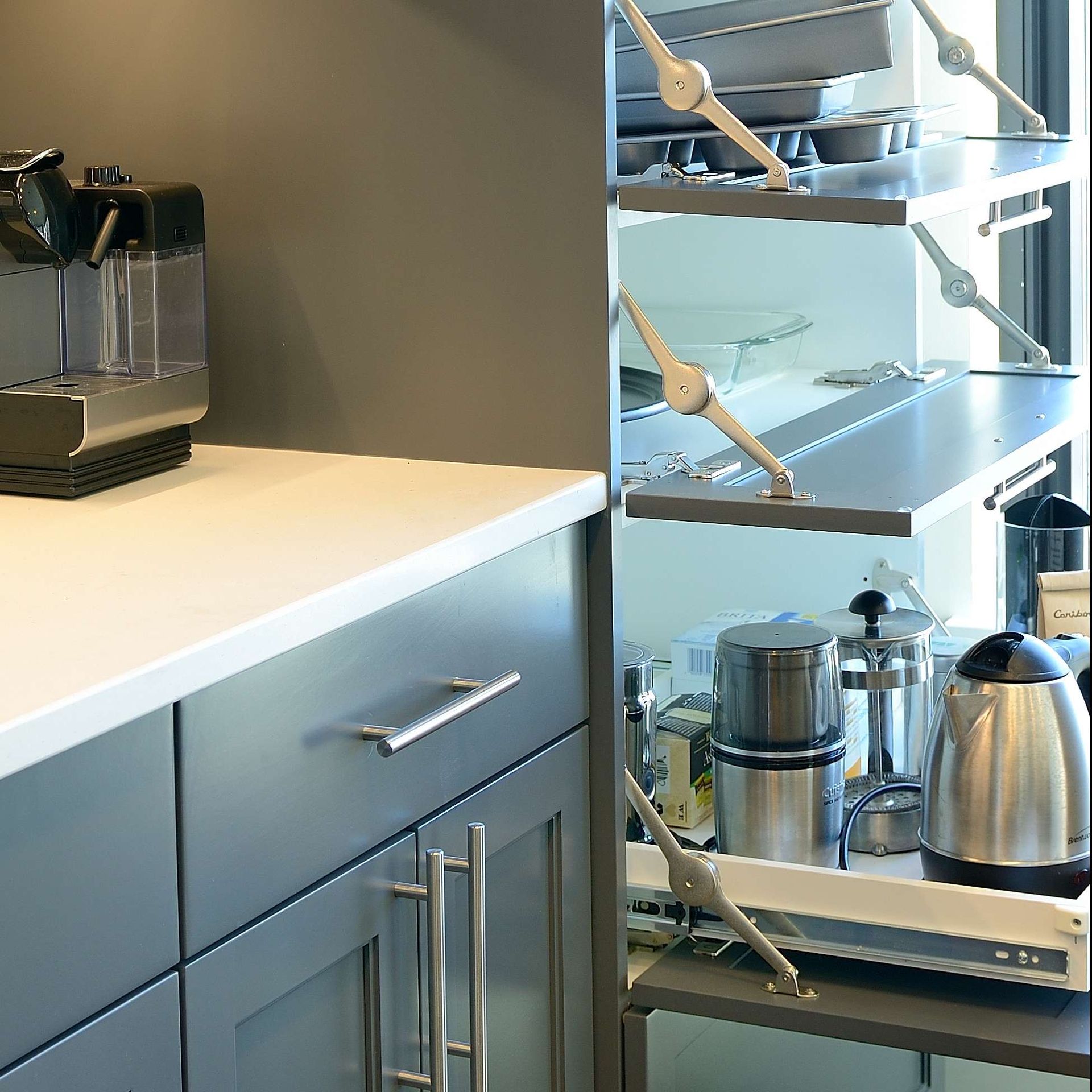 Gray kitchen cabinets with stainless steel appliances and pull-out shelves.