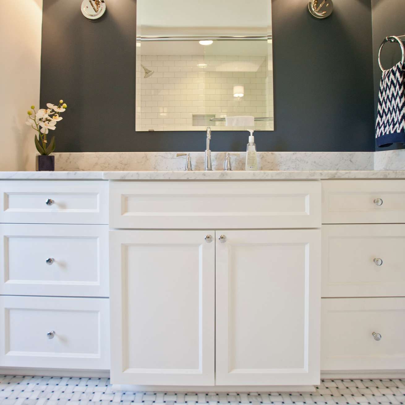 White bathroom vanity with dark gray wall and marble countertop.