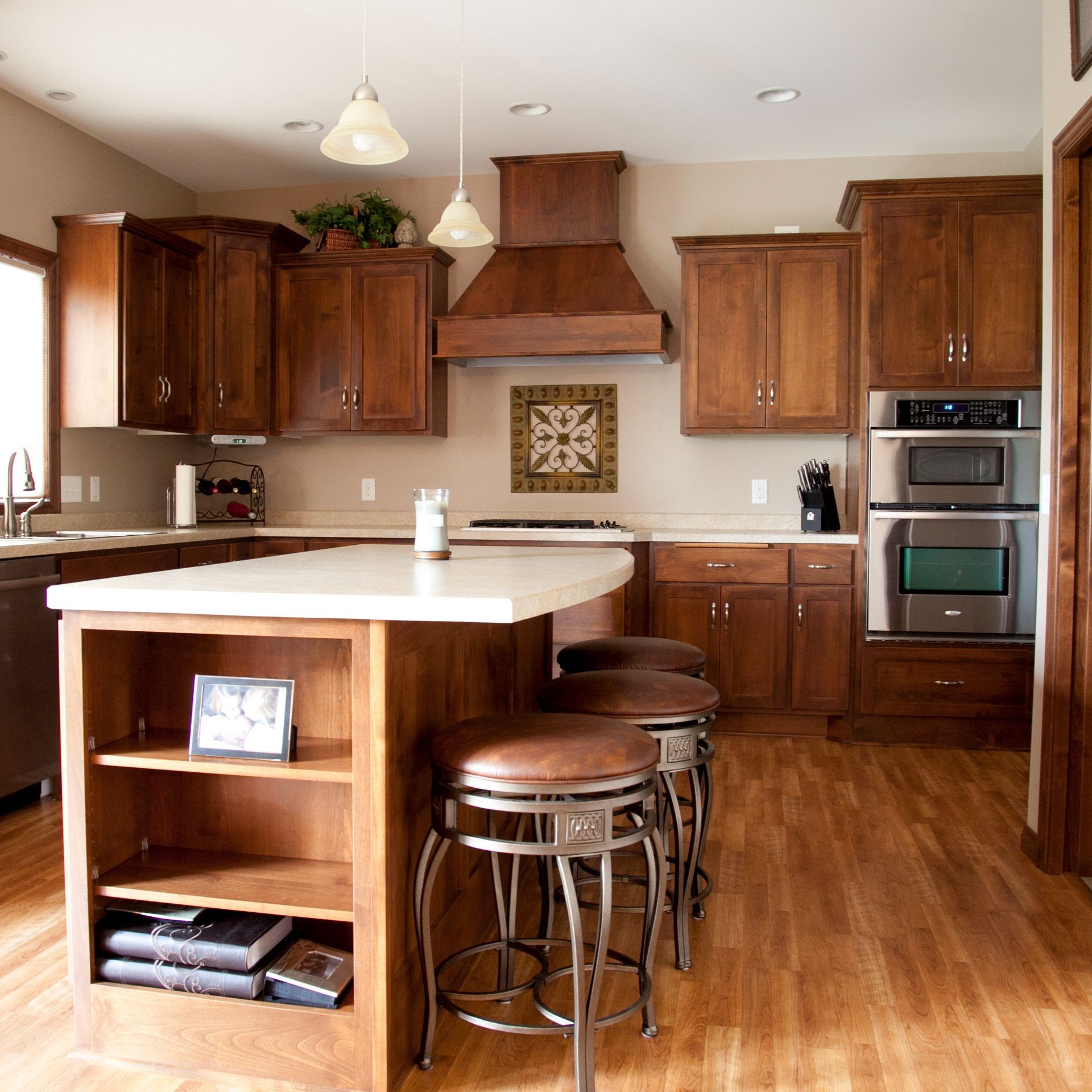 Kitchen with wooden cabinets, island with stools, and built-in appliances.