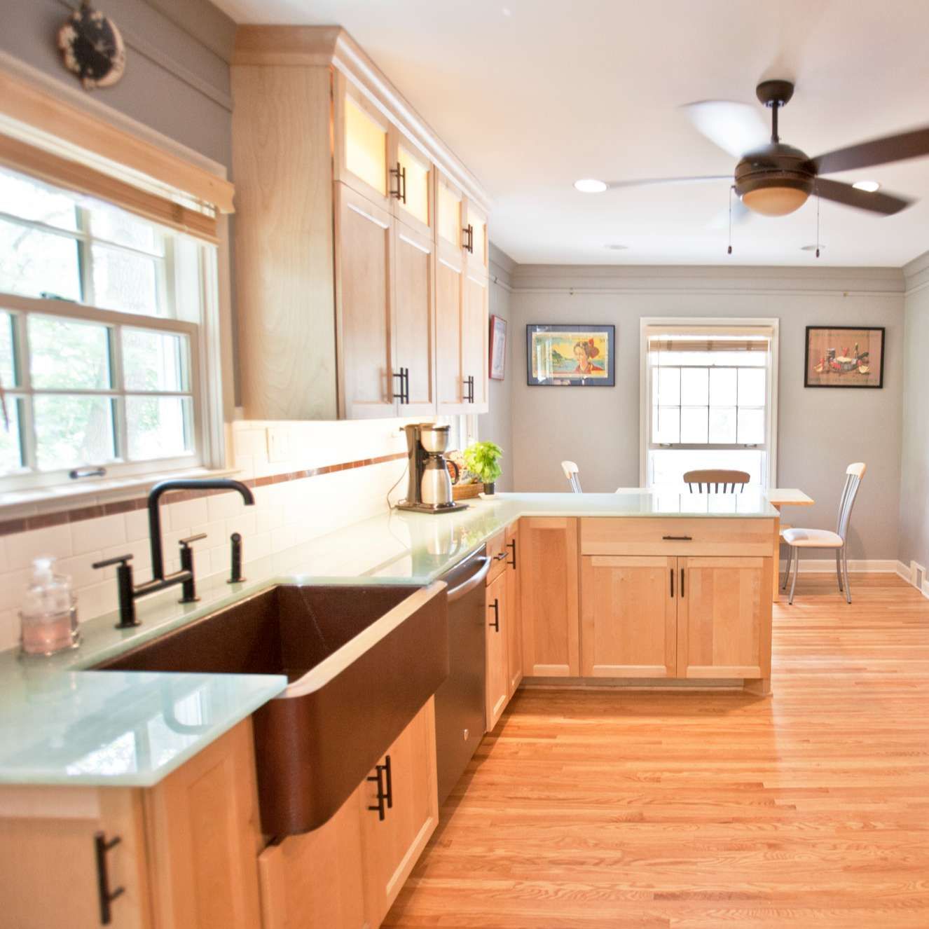 Kitchen with light wood cabinets, copper sink, and hardwood floors.