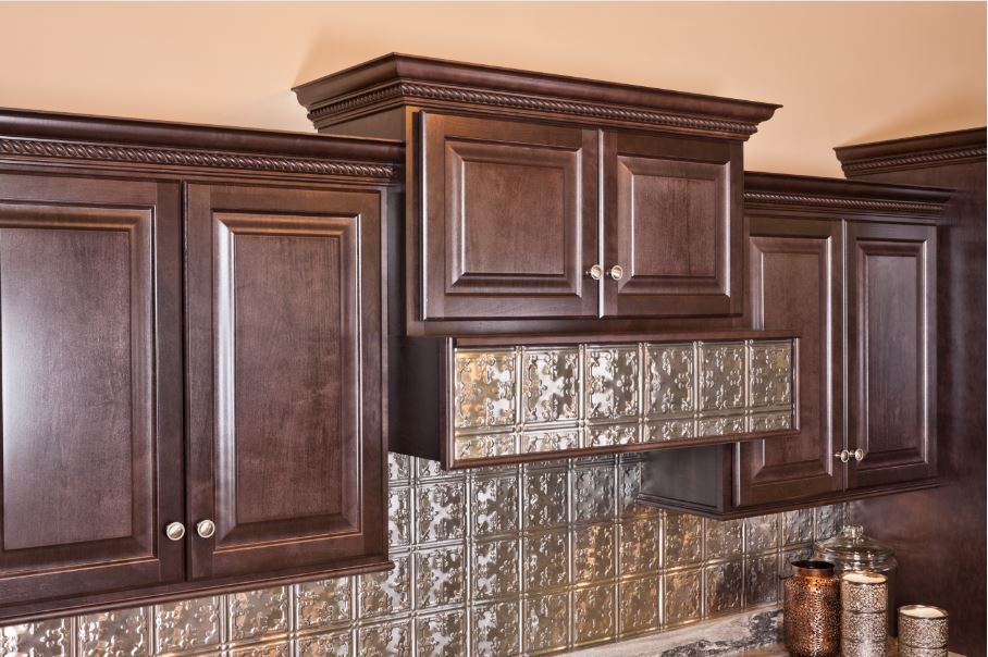 Dark wood kitchen cabinets with decorative backsplash and range hood.