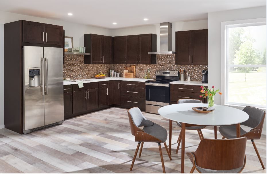 Modern kitchen with dark brown cabinets, stainless steel appliances, and a round dining table.