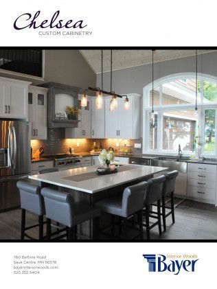 Modern kitchen with white and gray cabinets, island seating, and pendant lights.