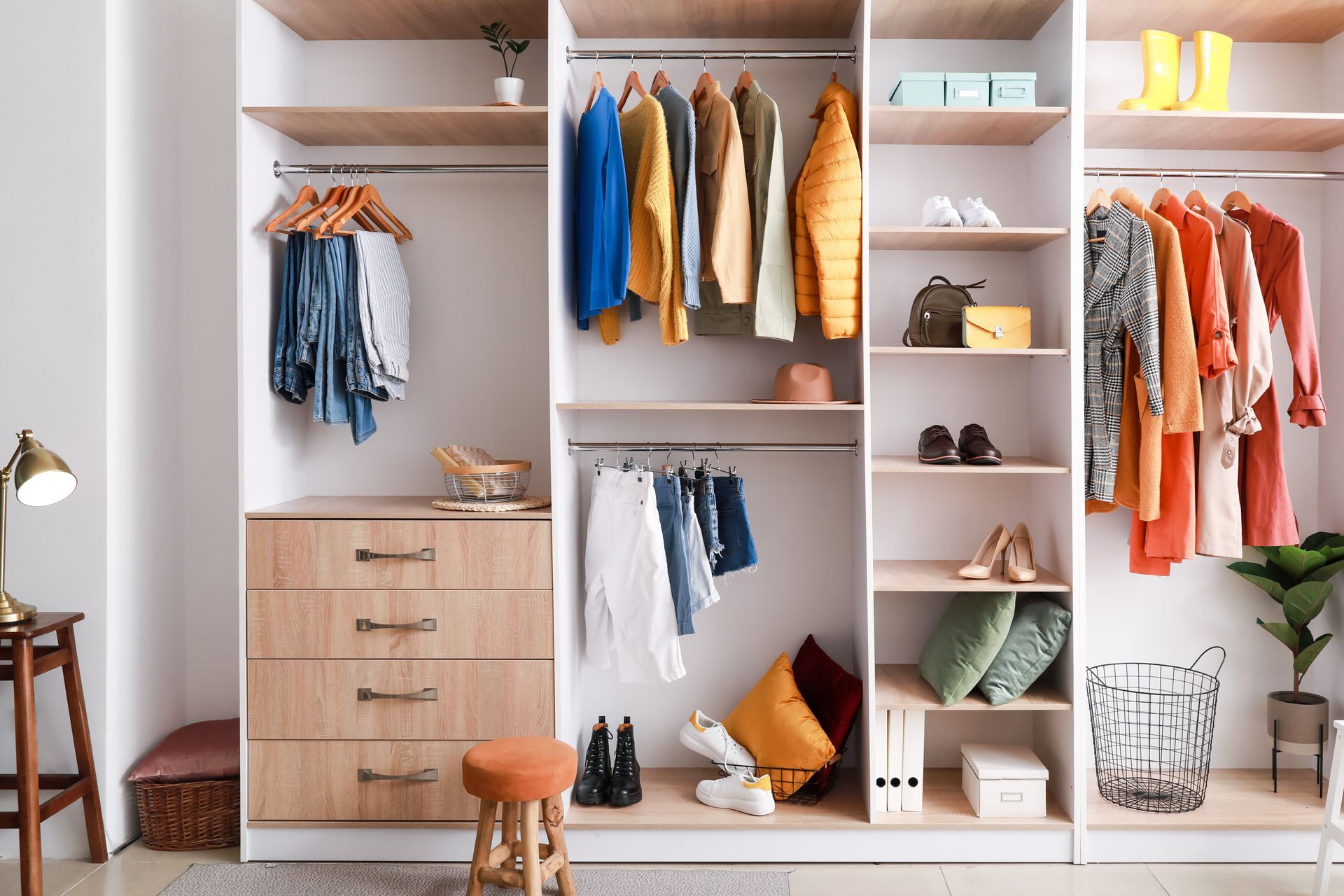 Walk-in closet with dark wood shelving, drawers, and light wood flooring.