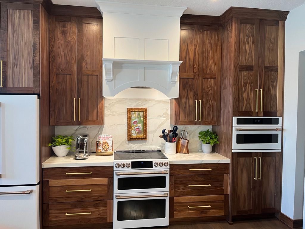 Kitchen with dark wood cabinets, white appliances, and gold hardware.