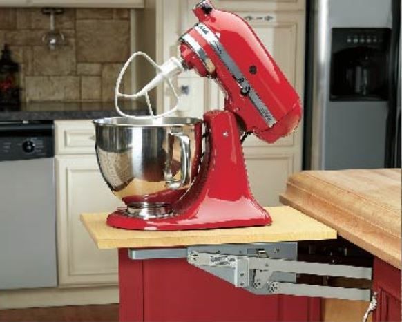 Red KitchenAid mixer on a pull-out shelf in a red cabinet, kitchen setting.