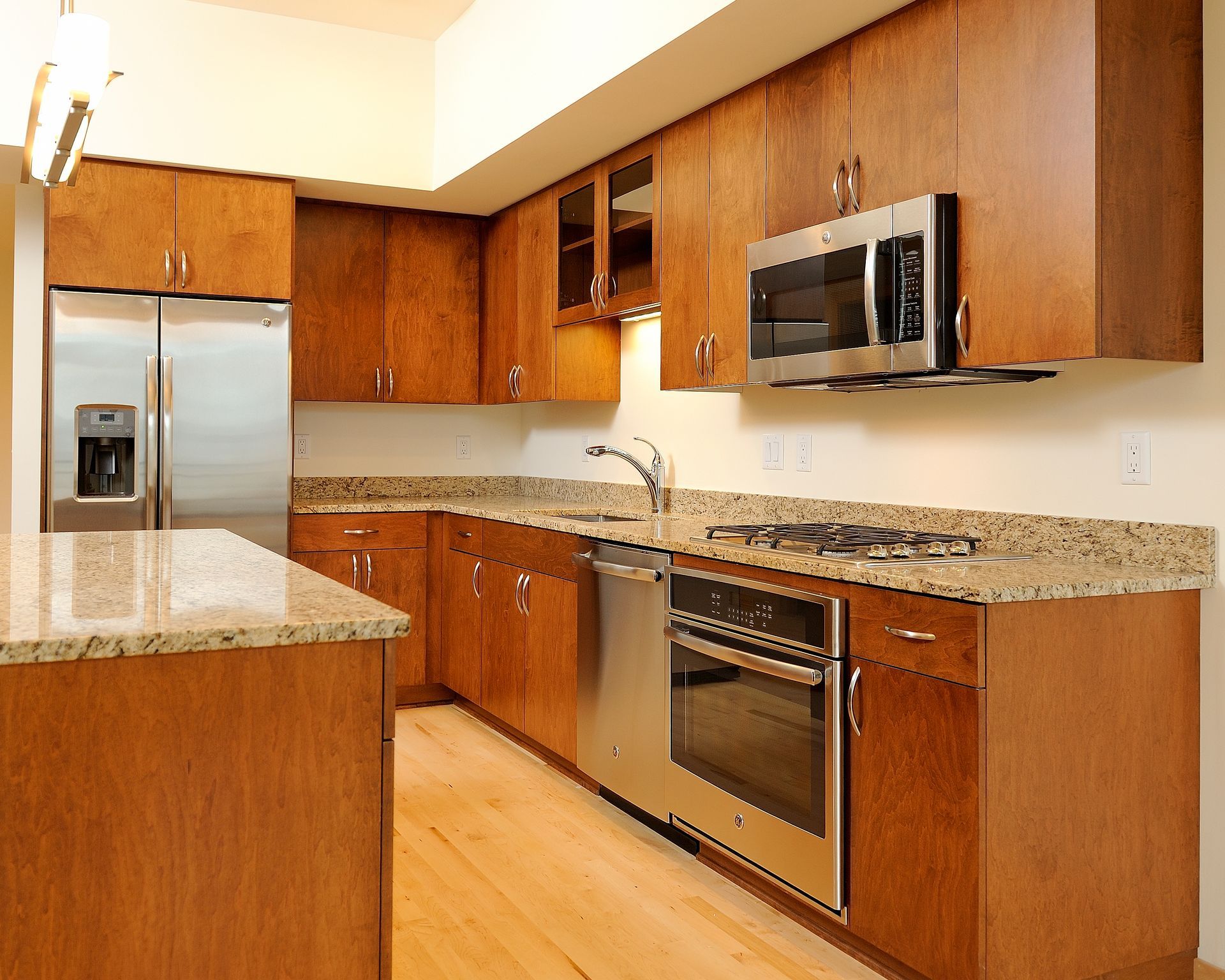 Kitchen with wooden cabinets, stainless steel appliances, and granite countertops.