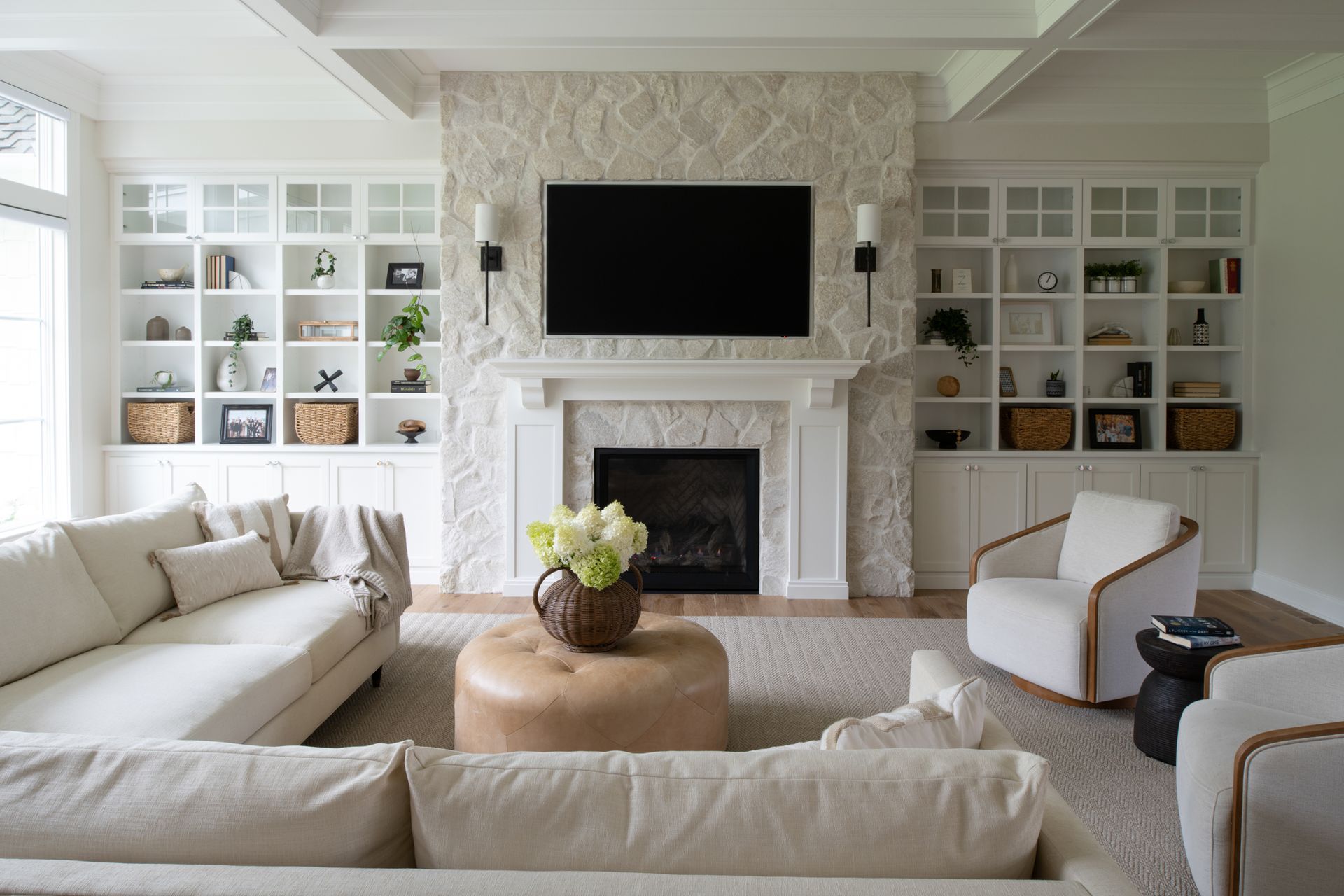 Living room with fireplace and built-in bookshelves, neutral tones, and light-colored furniture.