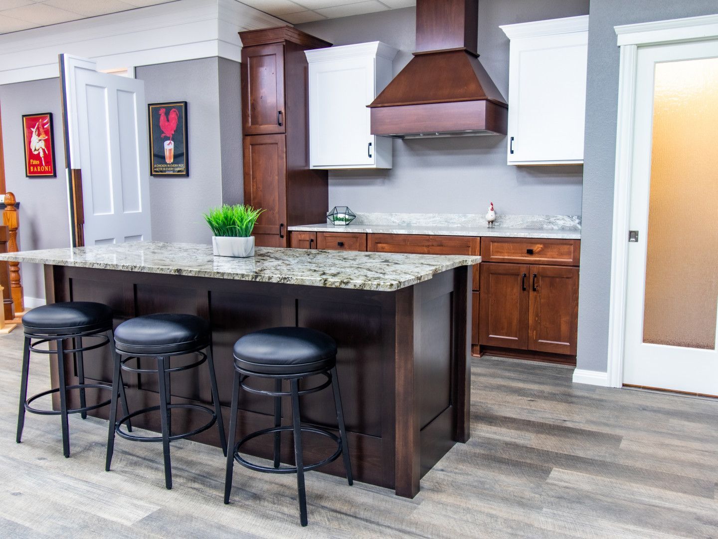 Kitchen with island and stools, dark wood cabinetry, and granite countertops.