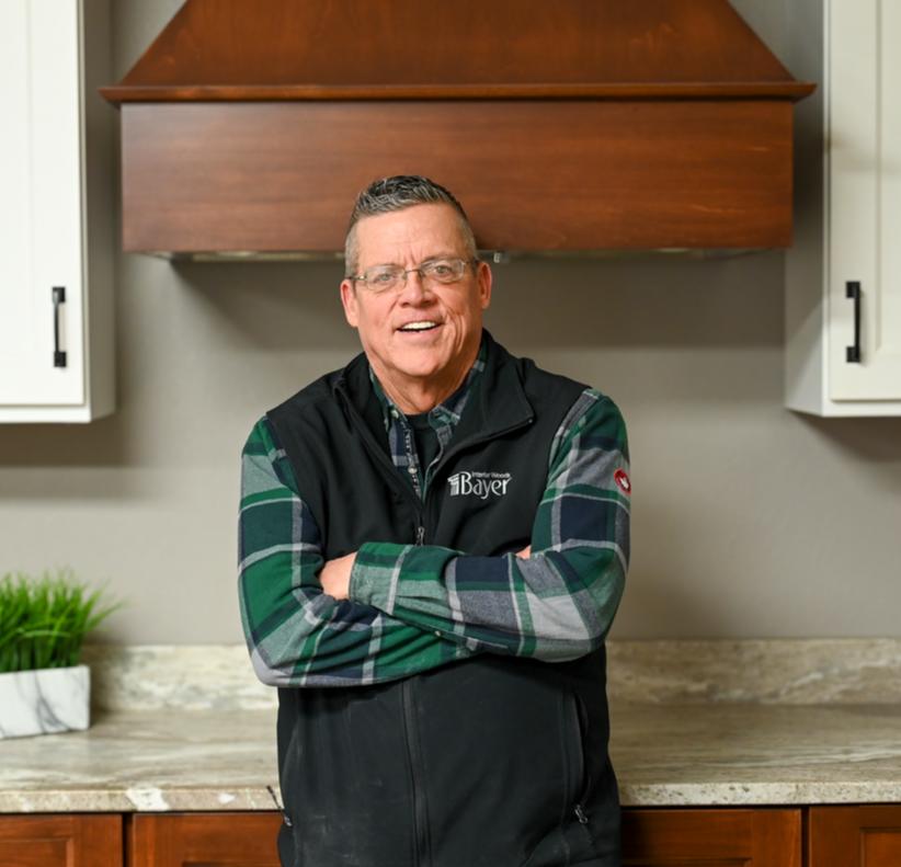 Smiling man with glasses, wearing a blue shirt with a white collar, and a spiky hairstyle.