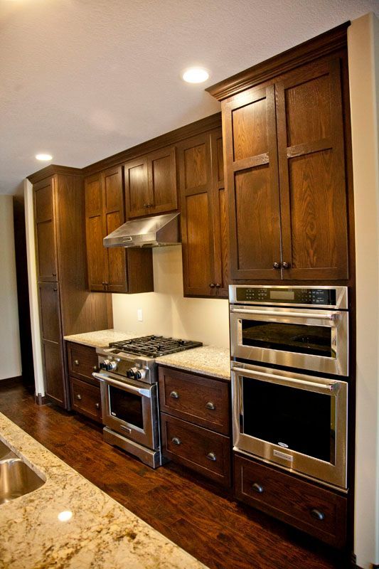 Dark wood kitchen cabinets with stainless steel appliances.