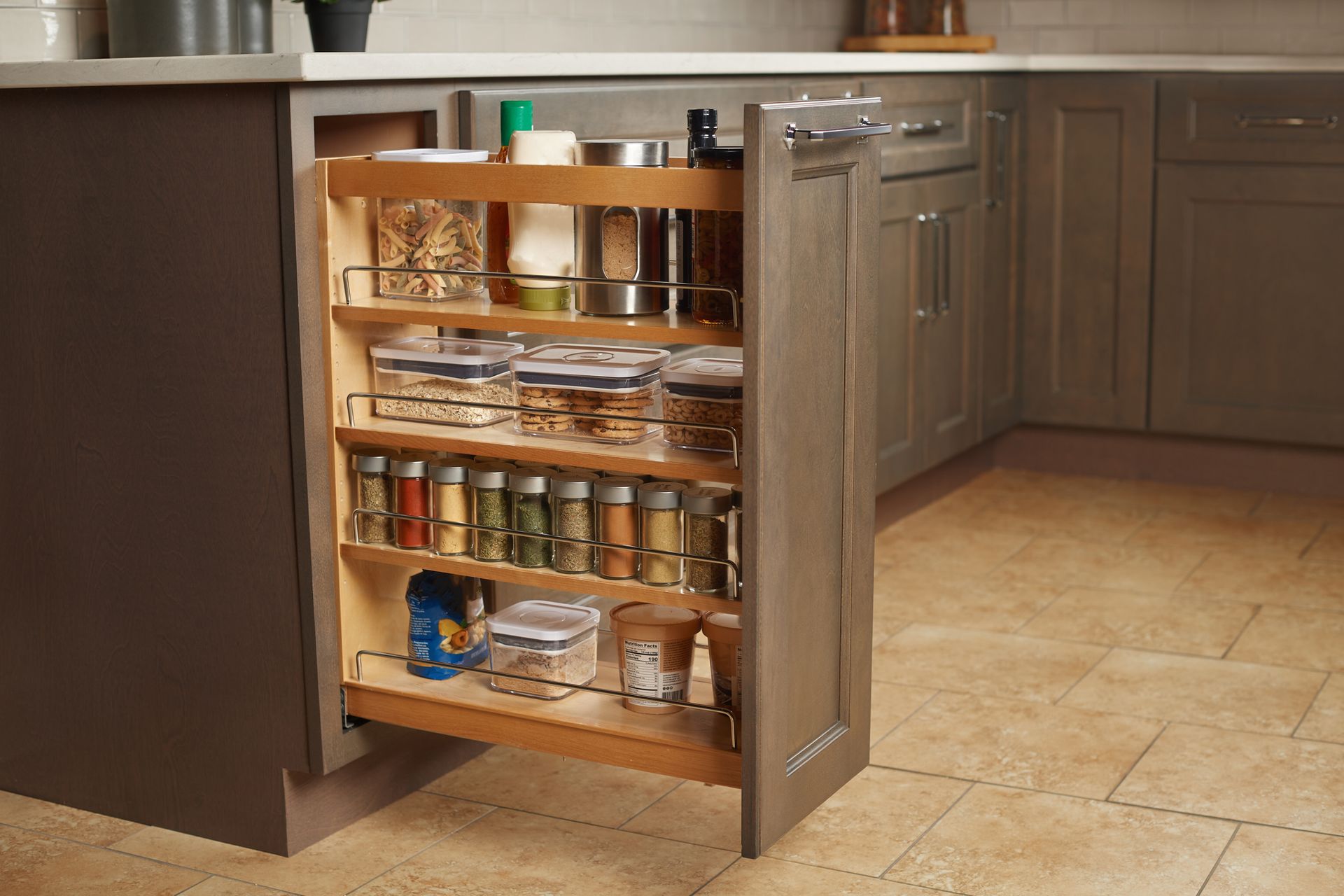 Open pull-out kitchen cabinet with spices, jars, and bottles. Light wood interior, gray cabinet exterior.