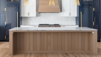 Modern kitchen with gray cabinets, mosaic backsplash, and decorative light fixture.