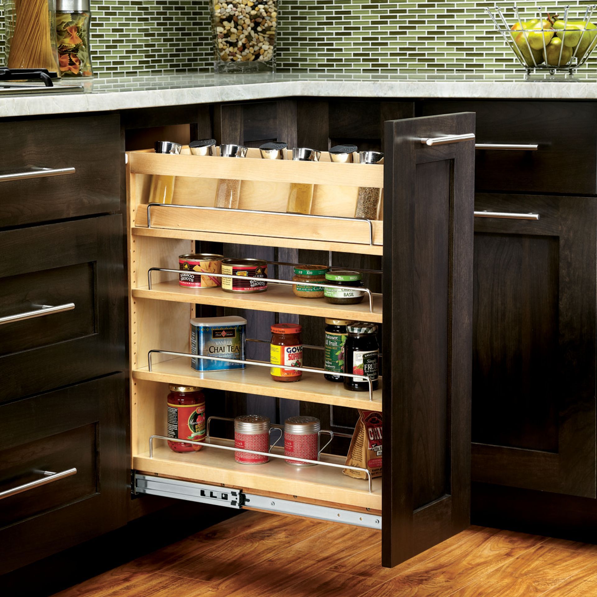 Pull-out spice rack in a dark brown kitchen cabinet, filled with various spice jars and bottles.