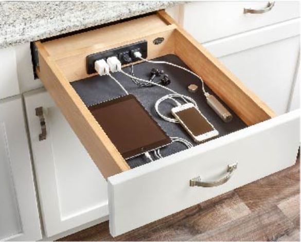 Open kitchen drawer with built-in charging station, holding a tablet, phone, and accessories.