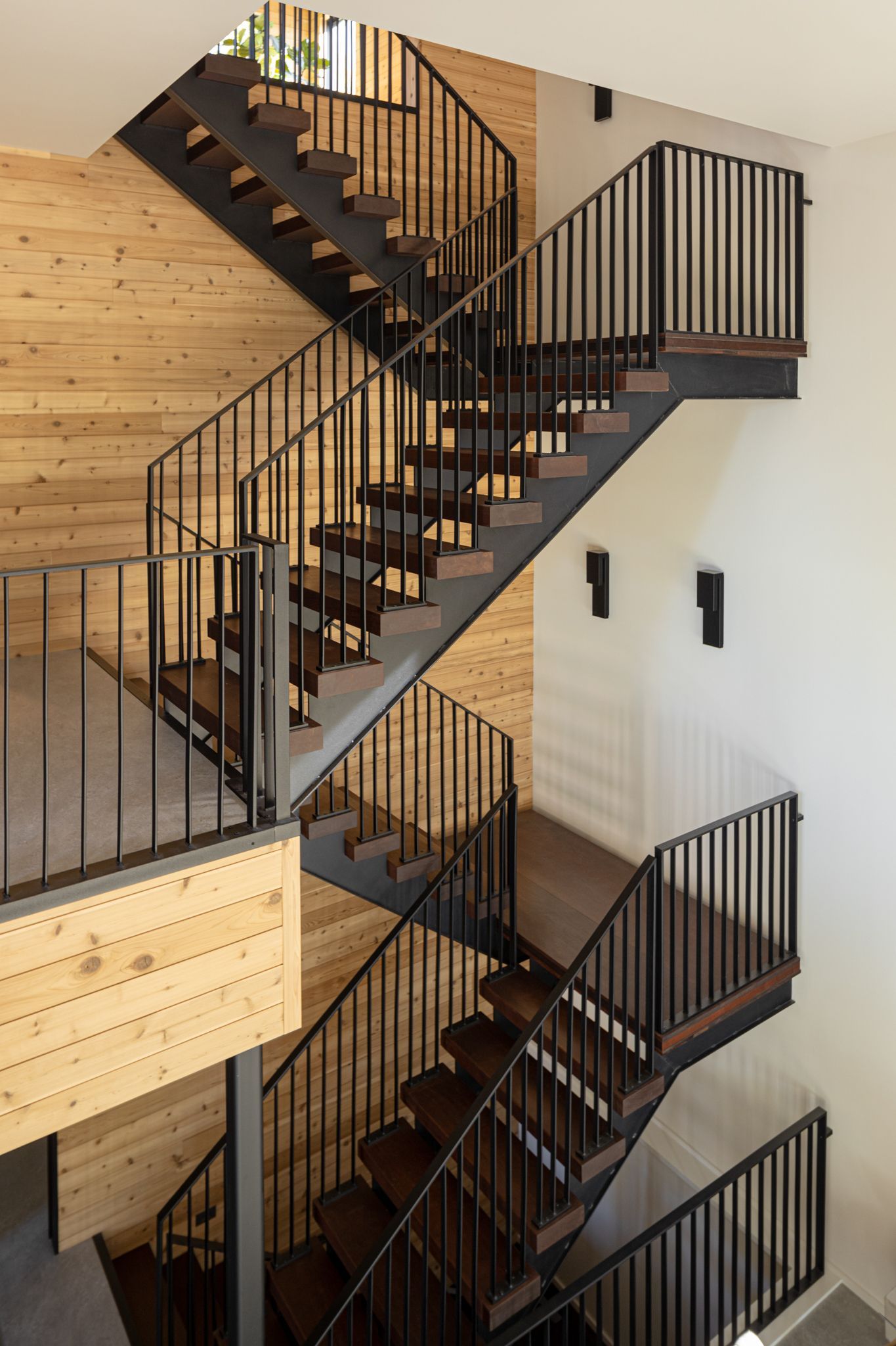 Wooden and black metal staircase in a modern building.
