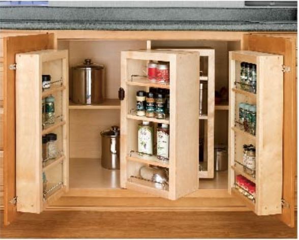 Kitchen cabinet with pull-out spice racks and a rotating center shelf filled with spice jars and bottles.