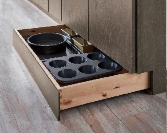 Open kitchen drawer with baking pans and utensils inside.