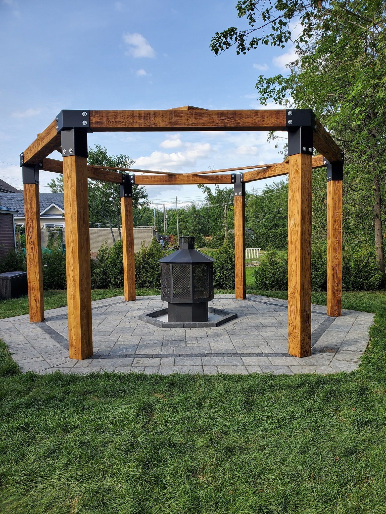 Une pergola en bois avec un foyer au milieu