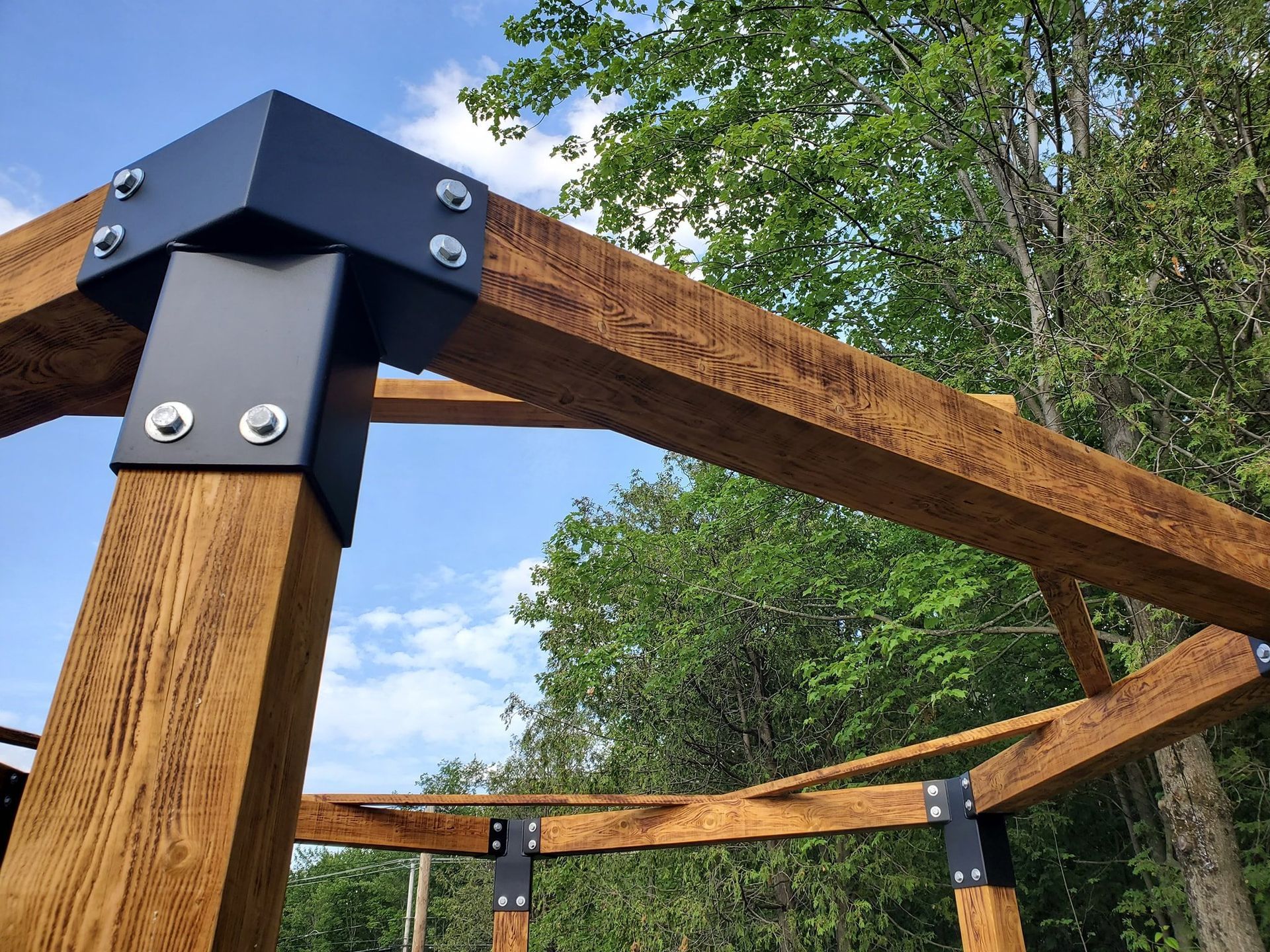 Un gros plan d'une structure en bois avec des arbres en arrière-plan