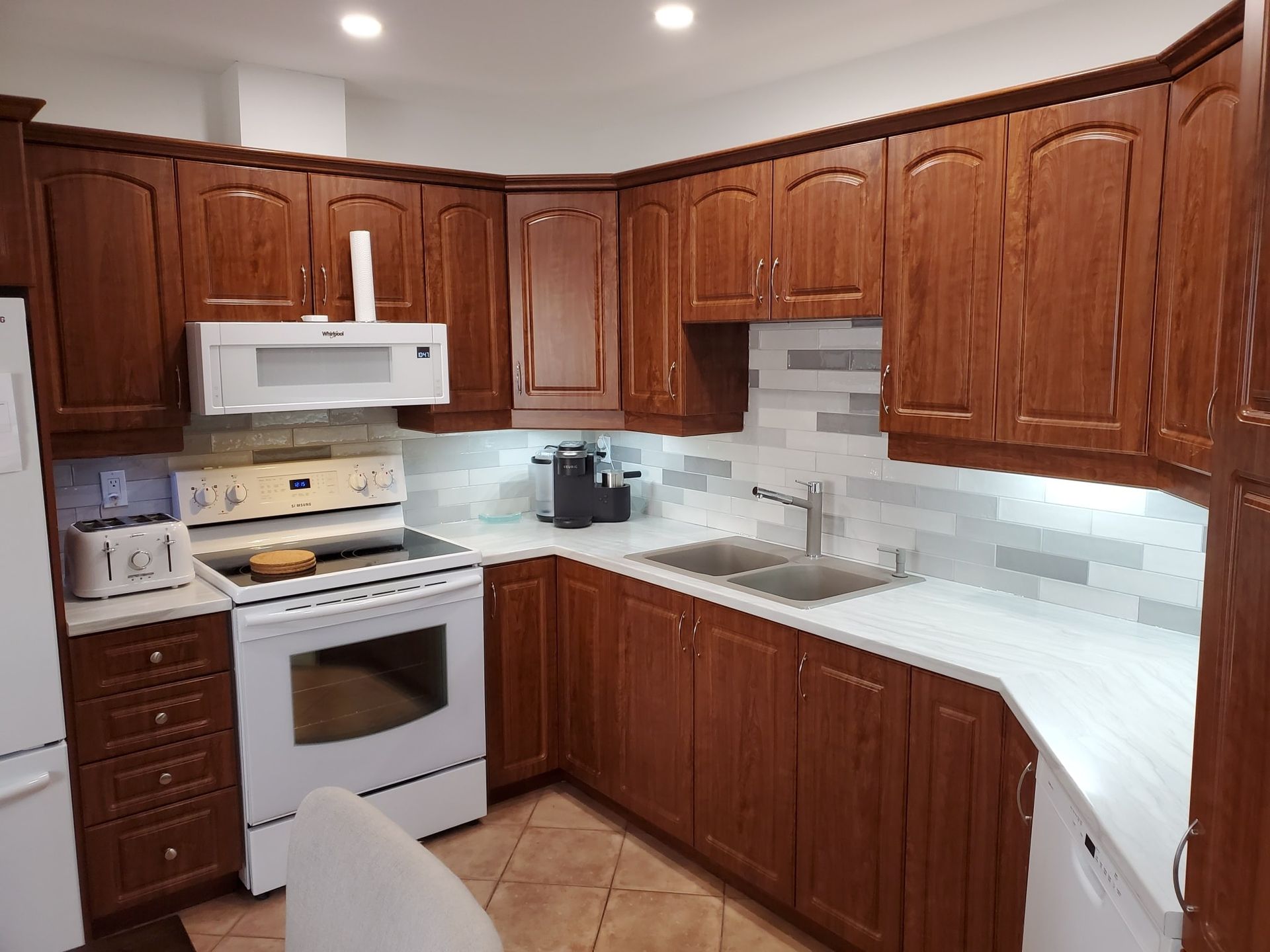 Une cuisine avec des armoires en bois et des appareils électroménagers blancs