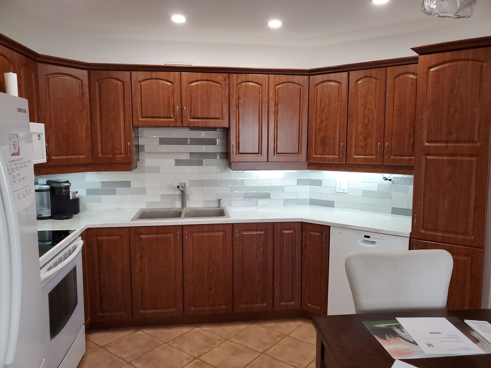 Une cuisine avec des armoires en bois, un réfrigérateur blanc, un évier et une cuisinière.