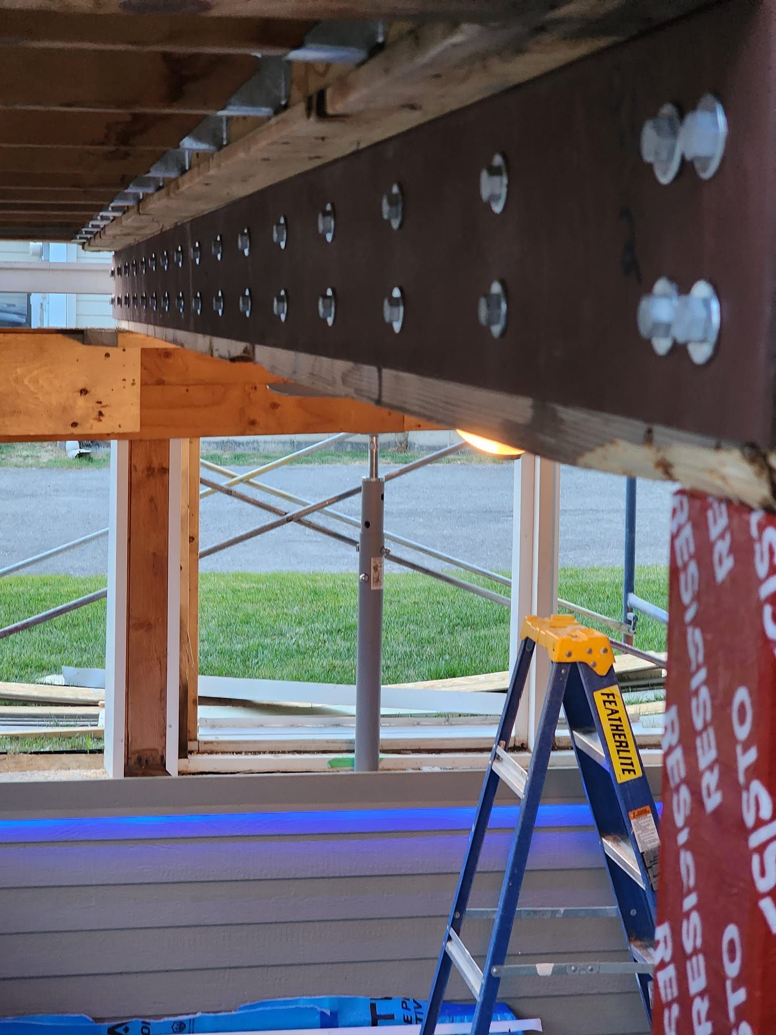 Une échelle se trouve sous une poutre sur laquelle est écrit « échafaudage »